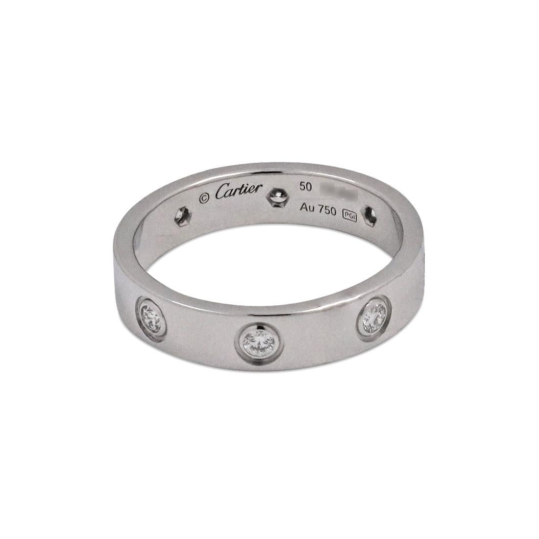 Authentic Cartier ‘Love’ wedding band crafted in 18 karat white gold and set with eight round brilliant cut diamonds (E-F, VS) weighing an estimated 0.19 carats total. Signed Cartier, 50, Au750, with serial number and hallmarks. Size 50 (5 1/4 US).