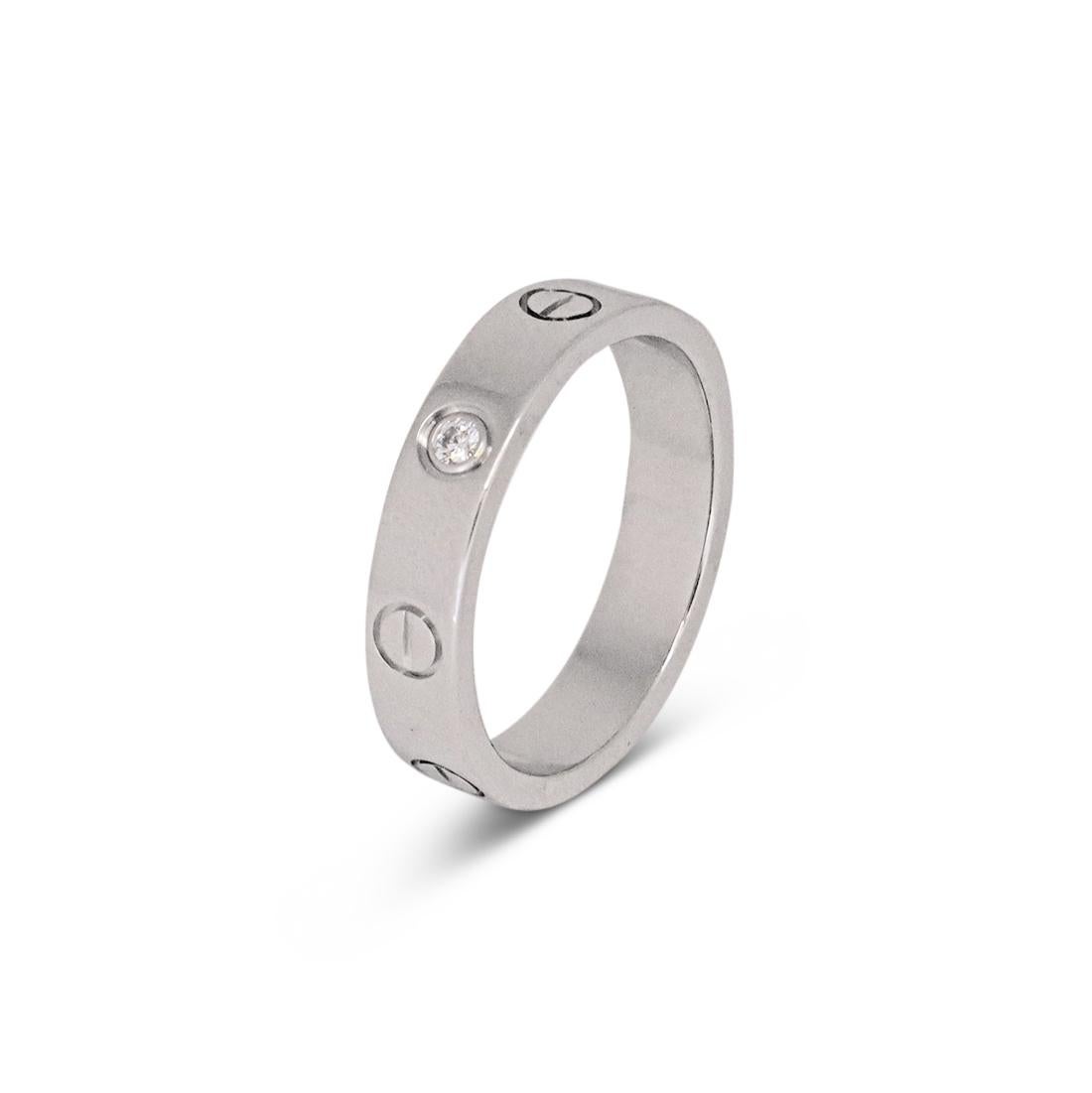 Authentic Cartier ‘Love’ wedding band crafted in 18 karat white gold and features one round brilliant diamond weighing an estimated 0.03 carat total weight. Signed Cartier, 51, Au750, with serial number and hallmarks. Size 51 (US 5 3/4). The ring is