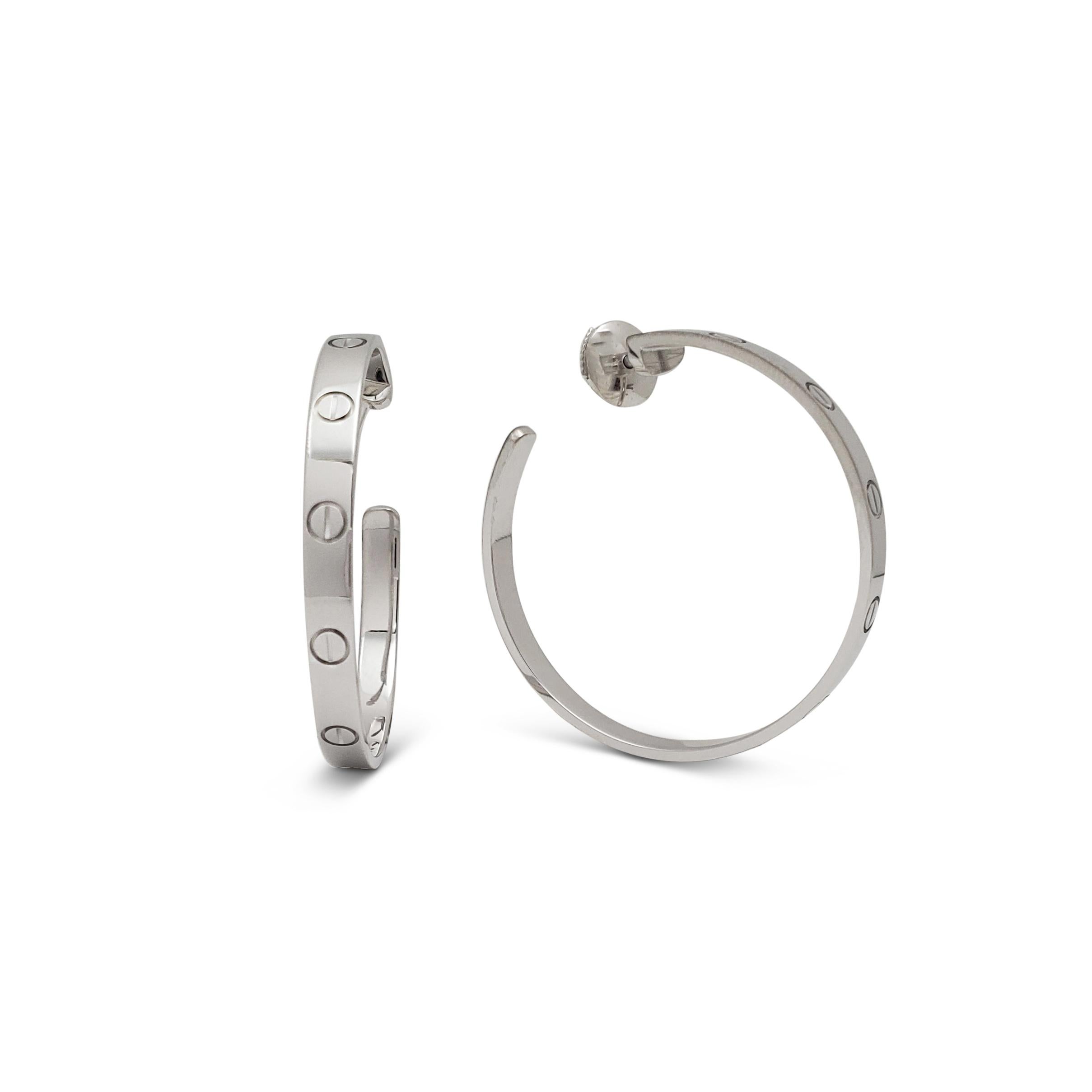 Authentic Cartier Love hoop earrings crafted in 18 karat white gold.  The earrings measure 3.6mm in width and 1.34 inches long.  Signed Cartier, 750, with serial number and hallmark.  Earring backs are signed Cartier, 750, 1999.  The earrings are