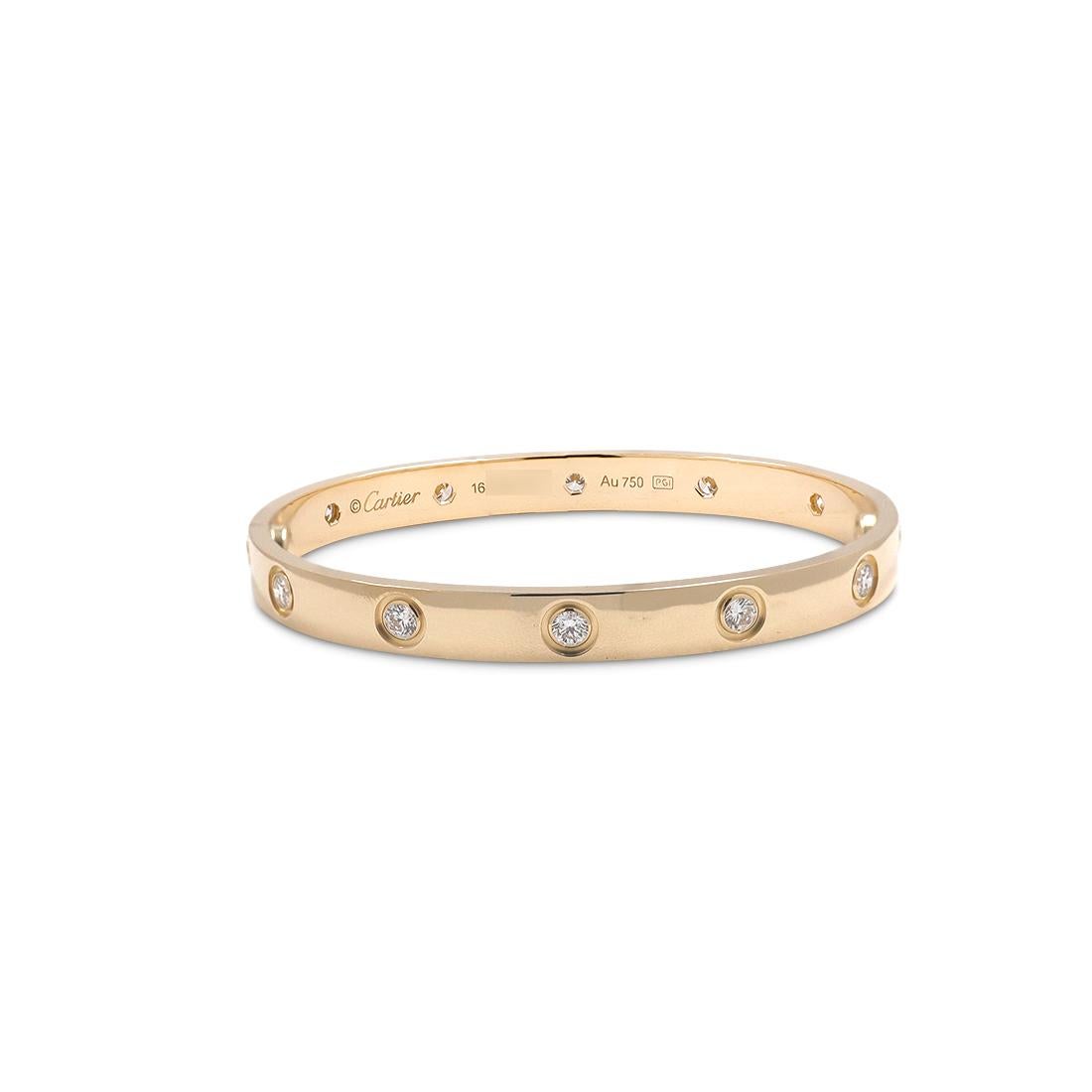 Authentic Cartier 'Love' bangle bracelet crafted in 18 karat yellow gold set with ten round brilliant cut diamonds (E-F in color, VS clarity) weighing an estimated 0.96 carats total. Signed Cartier, size 16, Au750, with serial number and hallmarks.