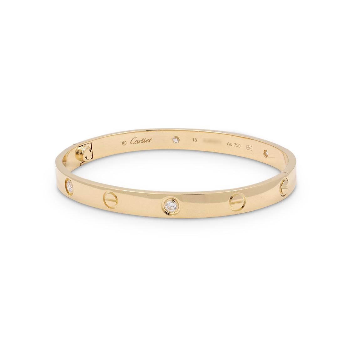 Authentic Cartier 'Love' bangle bracelet crafted in 18 karat yellow gold set with four round brilliant cut diamonds (G-H in color, VS clarity) weighing an estimated 0.20 carats total. Signed Cartier, size 18, Au750, with serial number. The bracelet