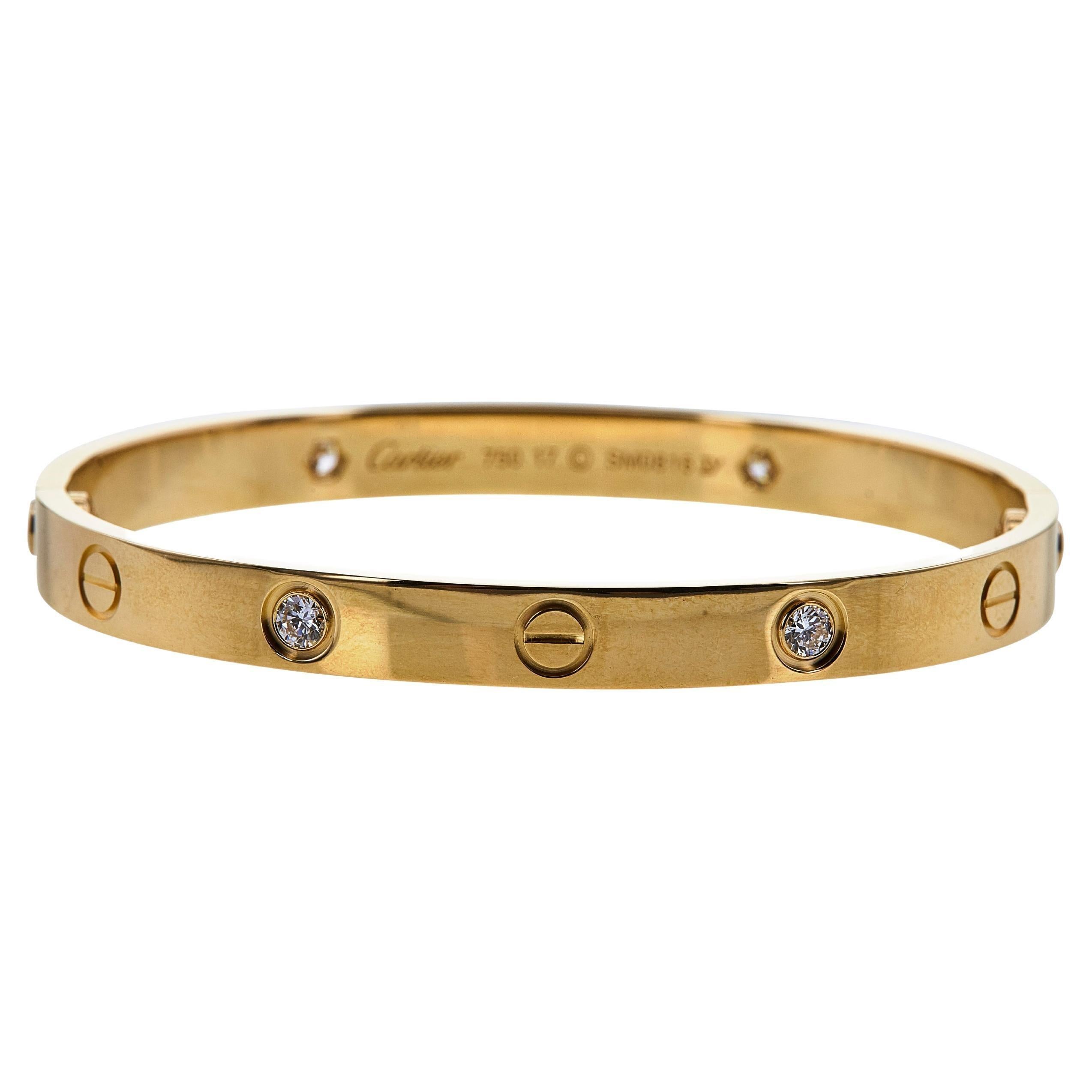 Authentic Cartier 'Love' bracelet crafted in 18 karat yellow gold, set with four round brilliant cut diamonds weighing an estimated 0.42 carats total weight. Size 17. Signed Cartier, 750, with serial number and hallmarks. The bracelet is presented