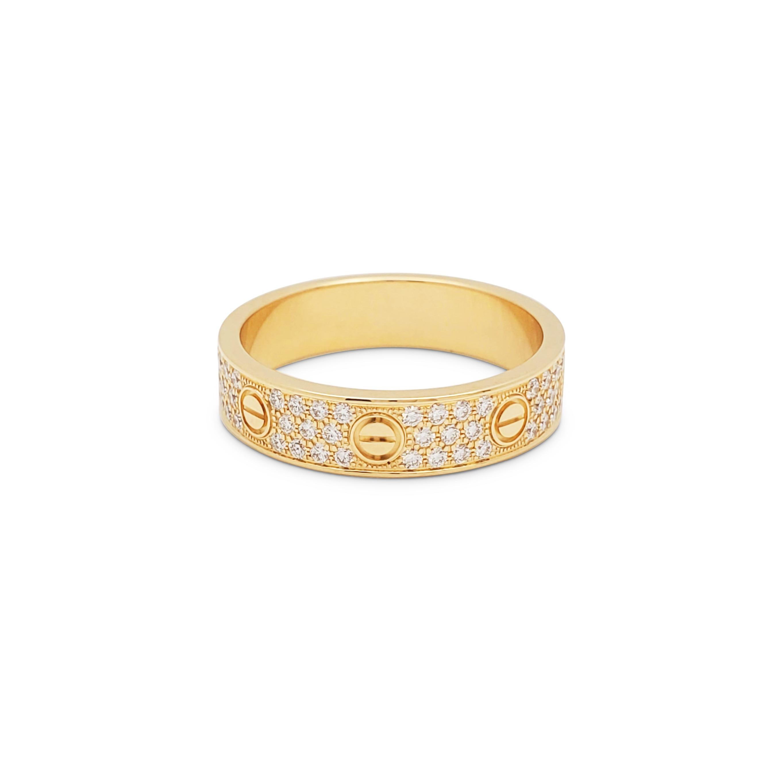 Authentic Cartier ‘Love’ Wedding Band crafted in 18 karat yellow gold and set with three rows of glittering pave set round brilliant diamonds weighing an estimated 0.31 carats.  Size 55 (US 7 1/4).  Signed Cartier, 55, Au750, with serial number and