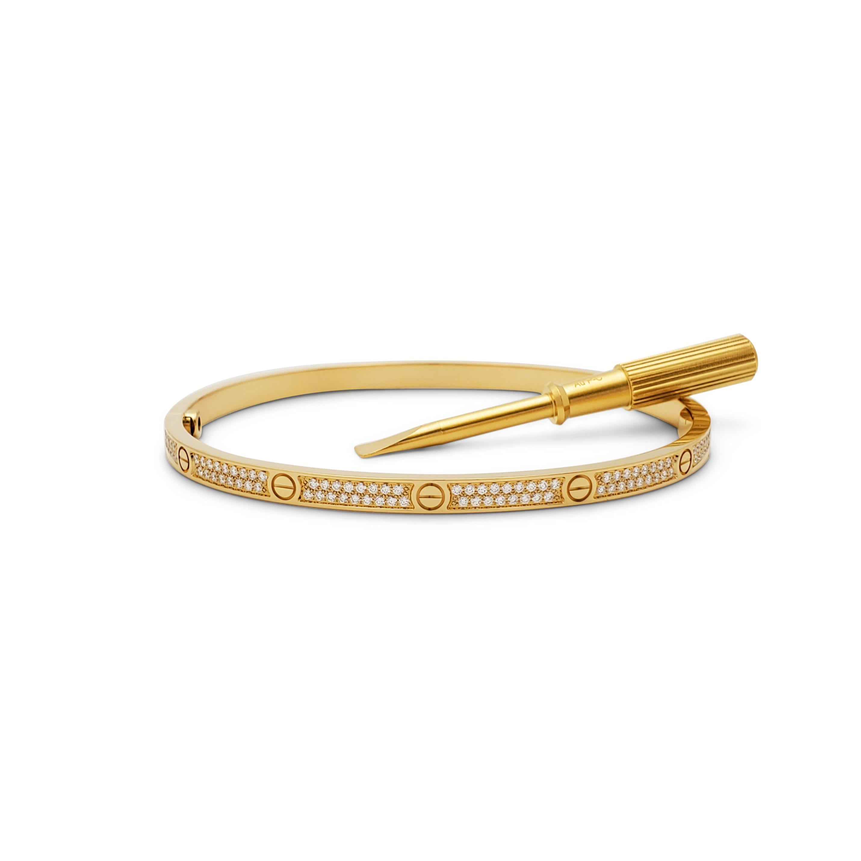 Authentic Cartier 'Love' bracelet crafted in 18 karat yellow gold is pave set with two rows of glittering round brilliant cut diamonds (E-F, VS) weighing an estimated 0.95 carats total. Size 18.  Signed Cartier, Au750, 18, with serial number and