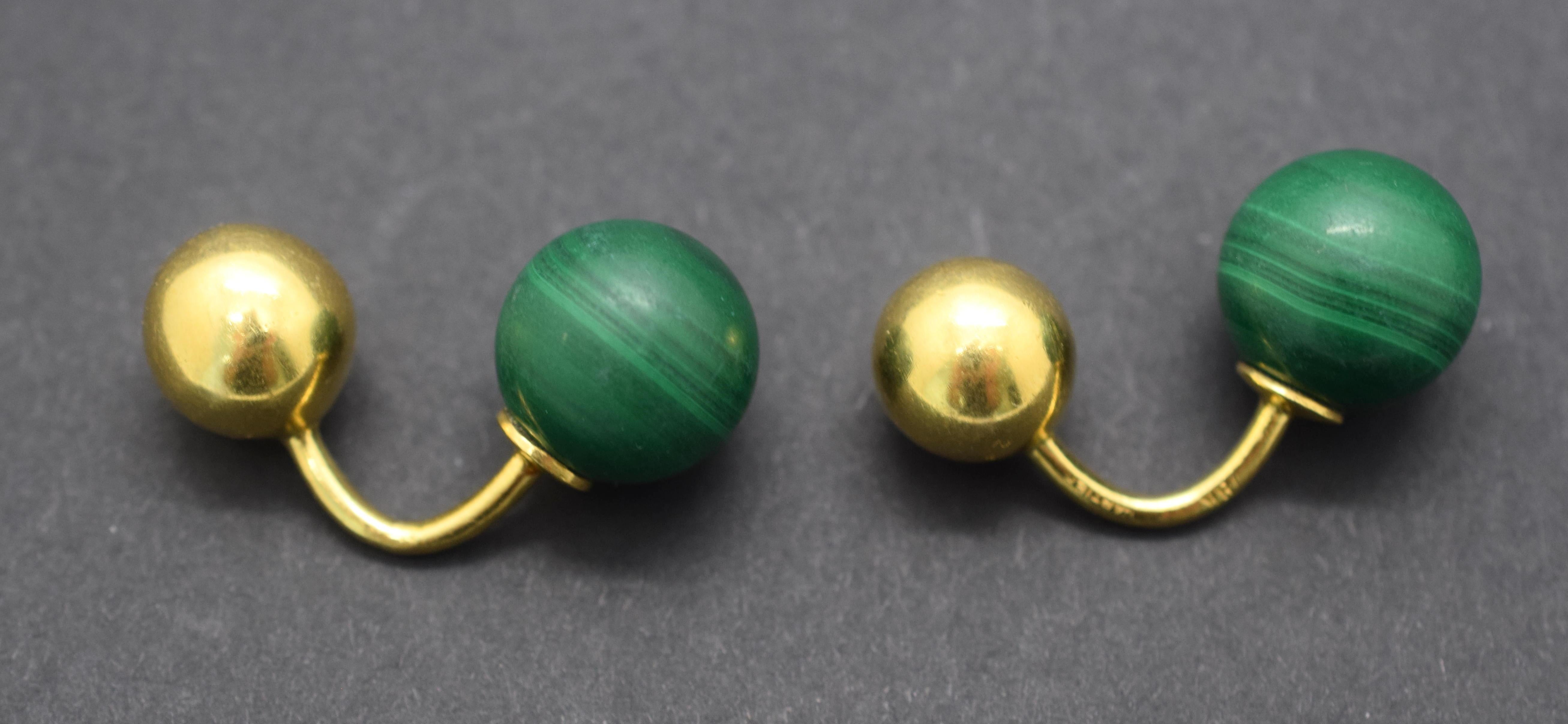 Gorgeous pair of CARTIER cuff links. The pair is set in 18 karat yellow gold. The focal point of the pair are two Malachite gemstones. The Malachite is cut into balls which give the pair a unique look that stand out and gives this pair an