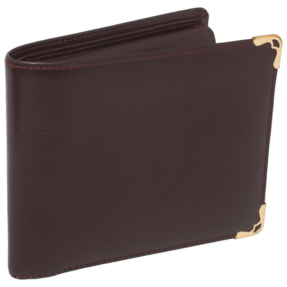 Embody the very definition of elegance and class with this bifold wallet from Cartier. The body of the wallet is made from maroon leather and features an embossed monogram of the label. The stunning wallet has gold-tone metal accents and is finished