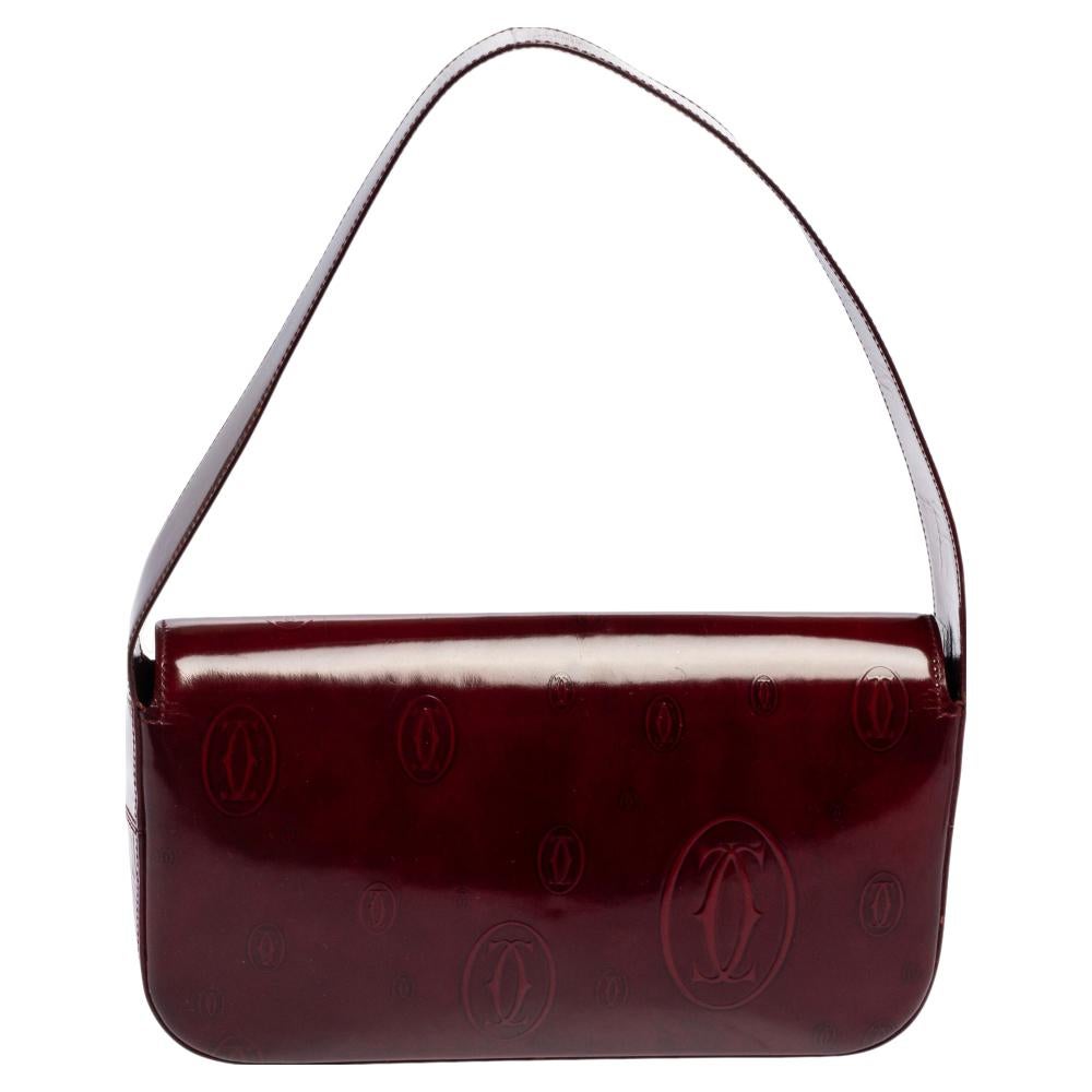 Cartier brings us this well-shaped Must De Cartier Baguette bag that has been crafted from patent leather and flaunts a flap closure. The fabric-lined interior is for your belongings and the bag is complete with a shoulder strap.

