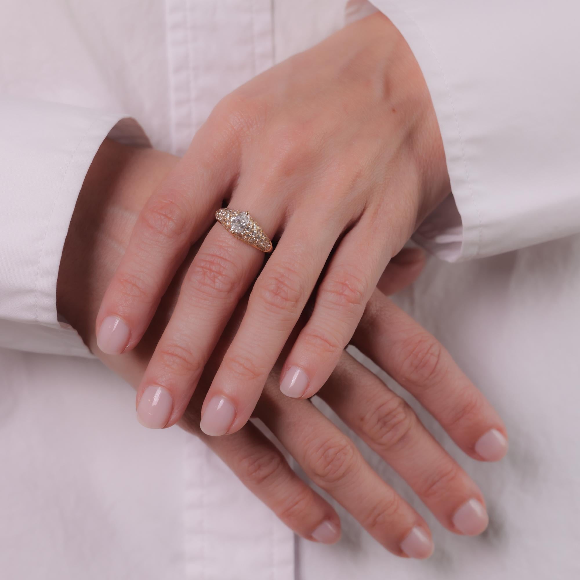This vintage Cartier ring features a marquise-cut diamond of approximately 0.50 carats, F color, VS clarity, accented by 54 round brilliant diamonds totaling approximately 0.80 carats, F color, VS clarity, set in 18k yellow gold. Circa