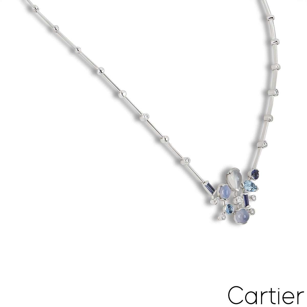 An 18k white gold Meli Melo necklace by Cartier. The necklace features a motif in the centre set with a cluster of diamonds and multi-shaped gemstones in an array of blue and grey hues. The necklace measures approximately 14 inches in length and has