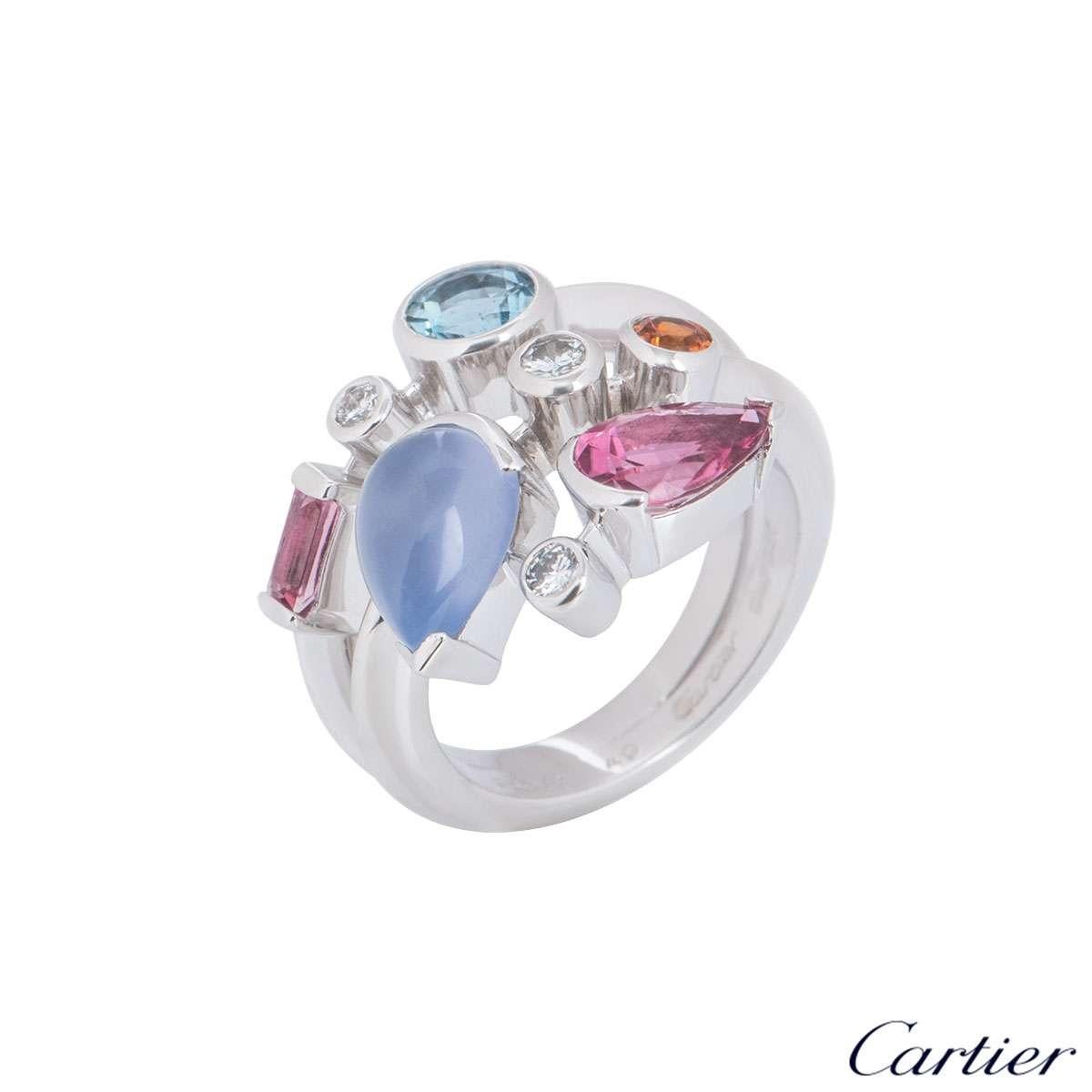 A platinum Cartier diamond and multi-gemstone ring from the Meli Melo collection. The ring comprises of 8 gemstones abstractly placed over 3 rows, consisting of diamonds, aquamarine, chalcedony, garnet and pink tourmaline. There are 3 round