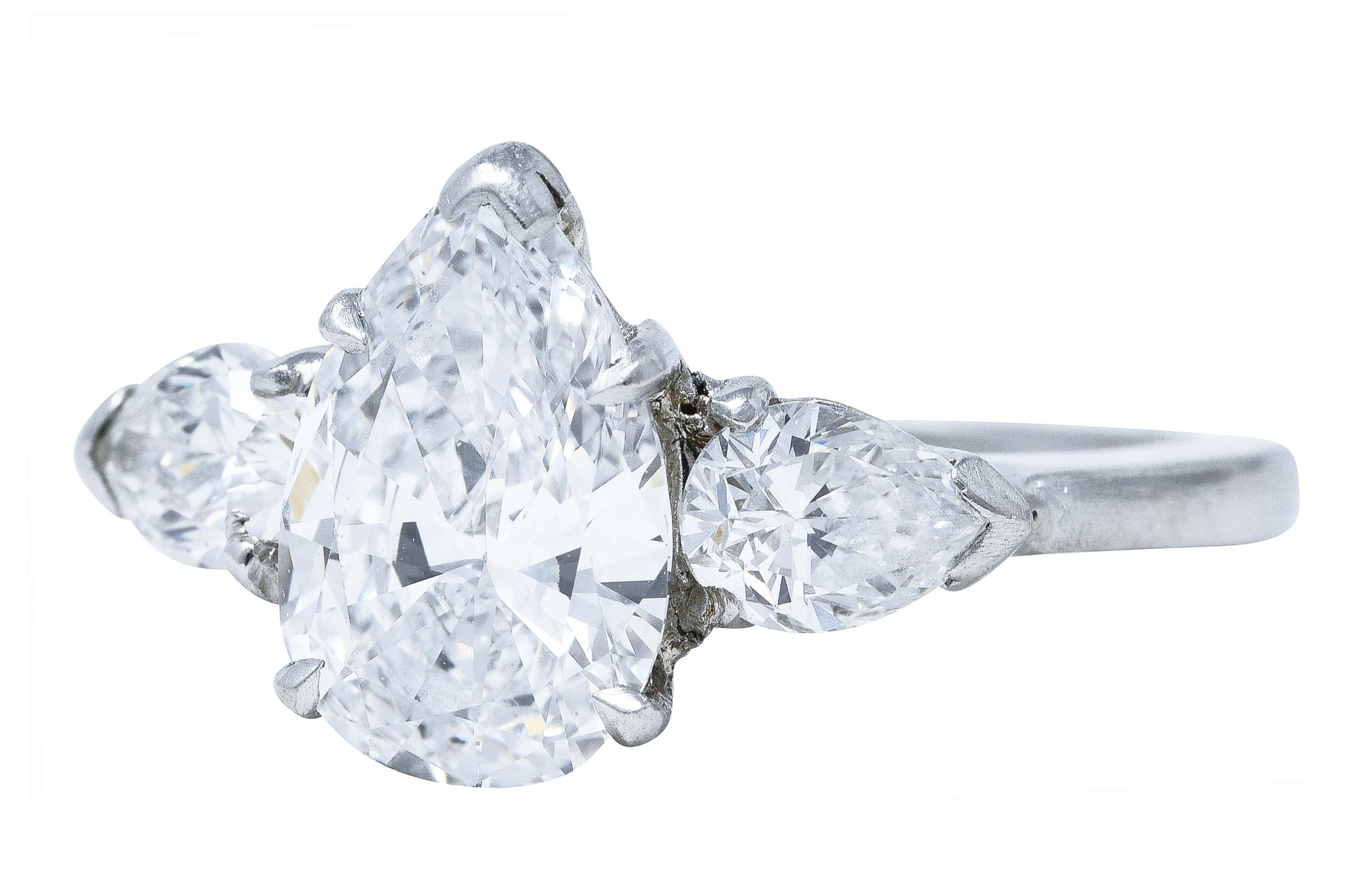 Ring centers basket set pear cut diamond weighing 1.56 carat total - D in color with VS1 clarity

Flanked by cathedral shoulders prong set with two pear cut diamonds

Weighing approximately 0.50 carat total - F/G in color with VS clarity

Tested as