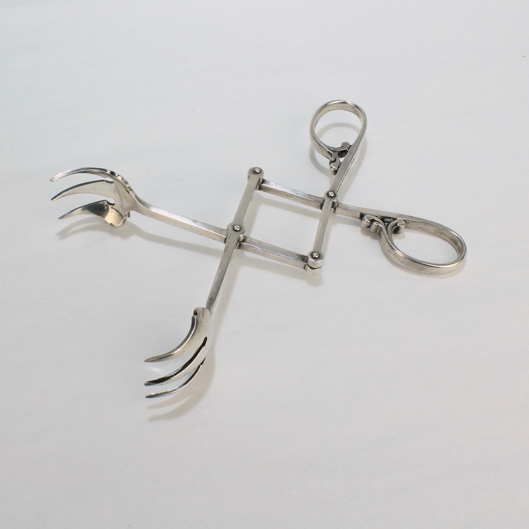 A fine pair of Mid-Century Modern sterling silver cocktail or ice tongs. 

With scissor handles and mechanical action. 

Marked for Cartier, Sterling and model no. 2232-1 to the handle.

A great pair of ice tongs from one the world's foremost