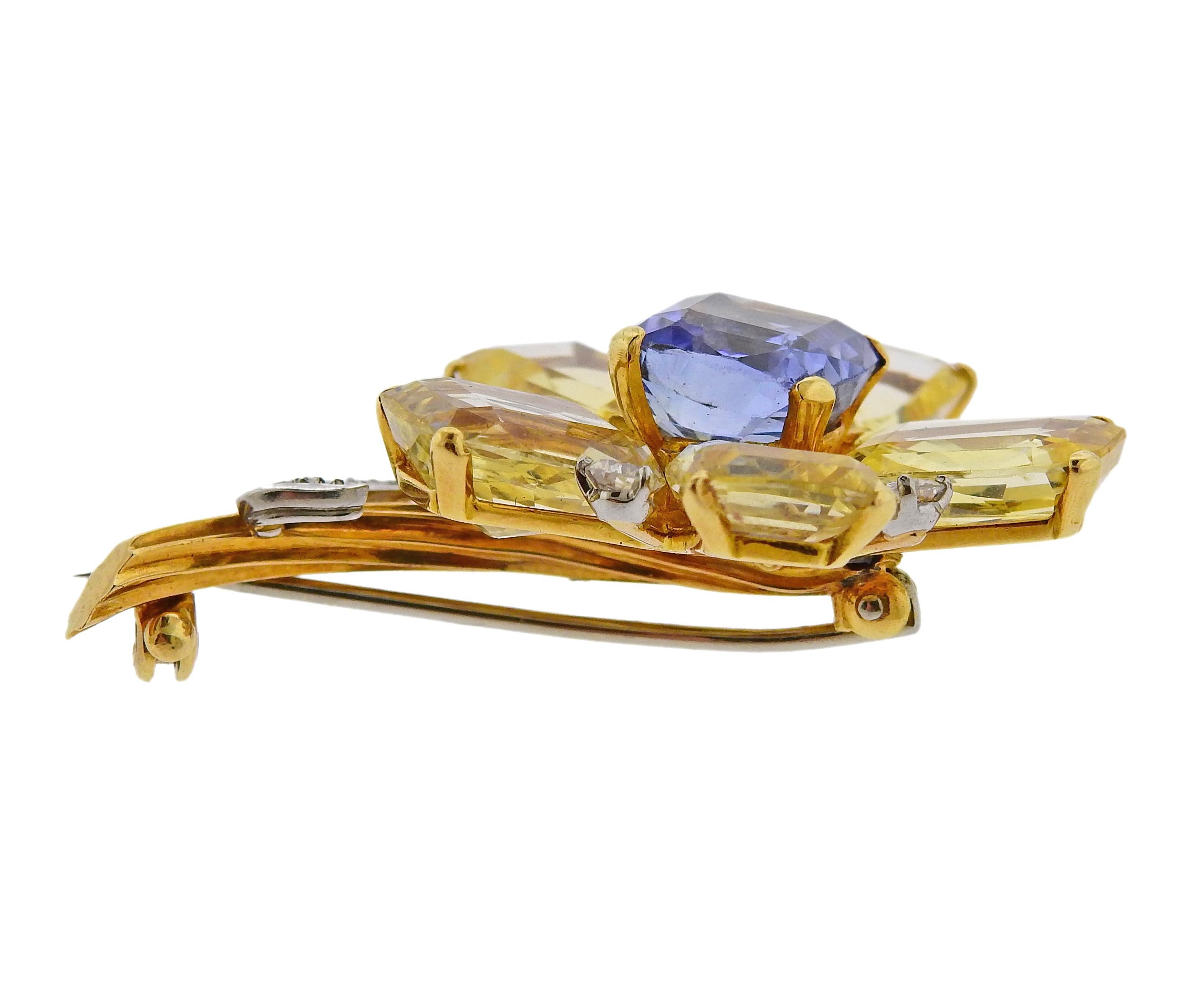 18k gold flower brooch by Cartier, set with approx. 0.85ctw in diamonds, center blue sapphire - approx. 5.50ct, and four yellow sapphire petals, each approx. 6 - 6.50cts.  The brooch is 46mm x 32mm. Marked Cartier. Weighs 17.7 grams.

SKU#PB-03022