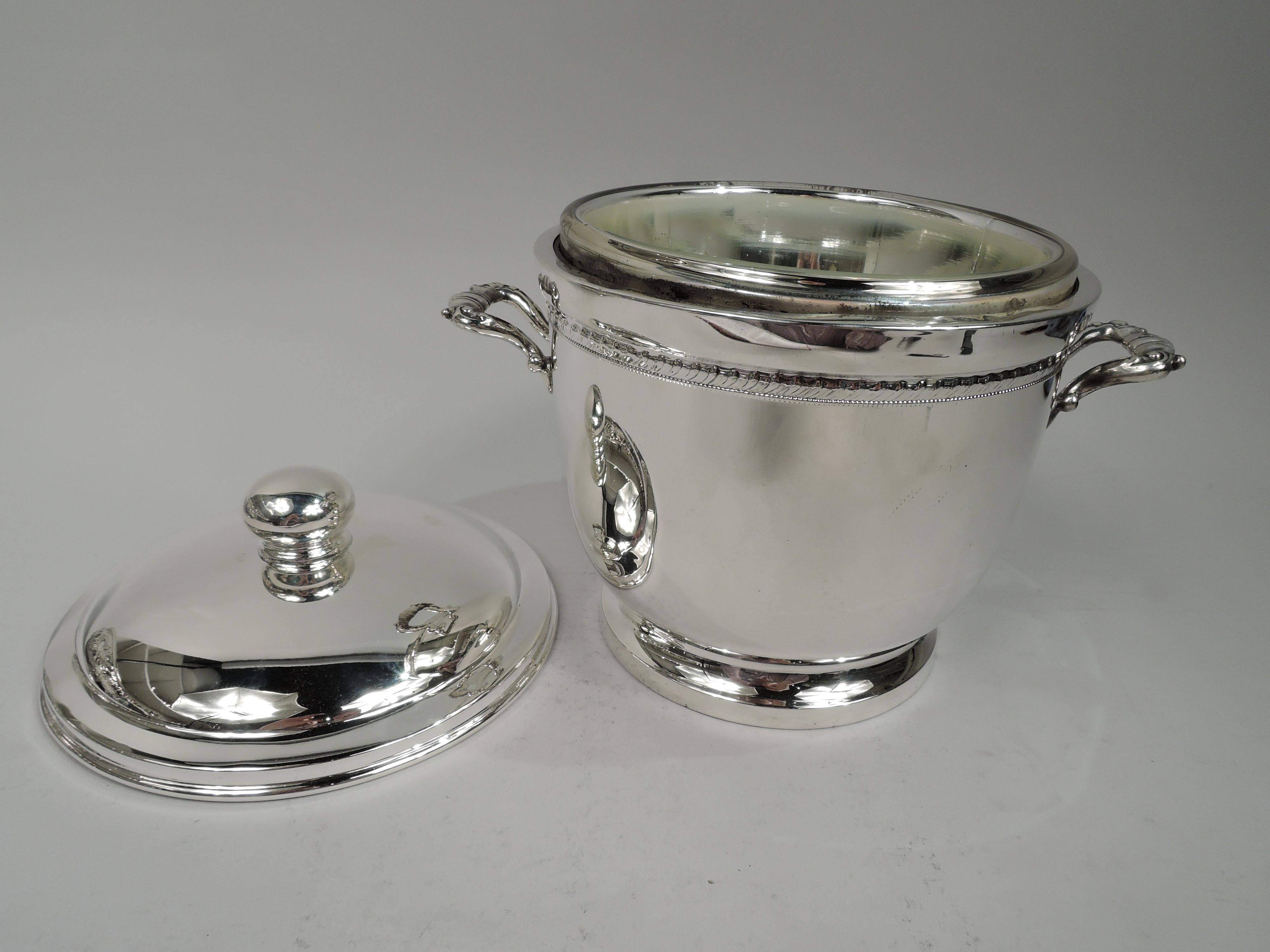 Midcentury Georgian sterling silver ice bucket. Retailed by Cartier in New York. Urn with gadrooned and beaded borders. Capped and scrolled side handles and raised foot. Cover domed with ball finial. Insulated interior. Fully marked including