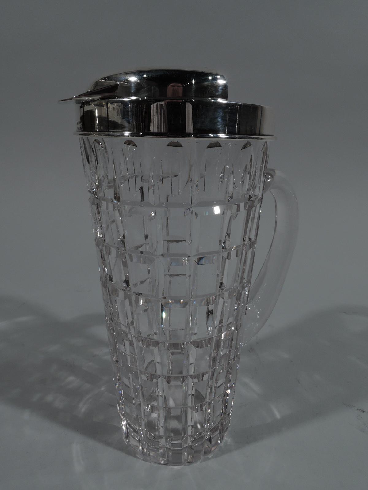 Mid-Century Modern sterling silver and glass bar pitcher. Retailed by Cartier in New York. Clear glass body with straight and tapering sides with c-scroll handle. Sterling silver collar with flat spout and raised ice guard. Faceted rectilinear grid