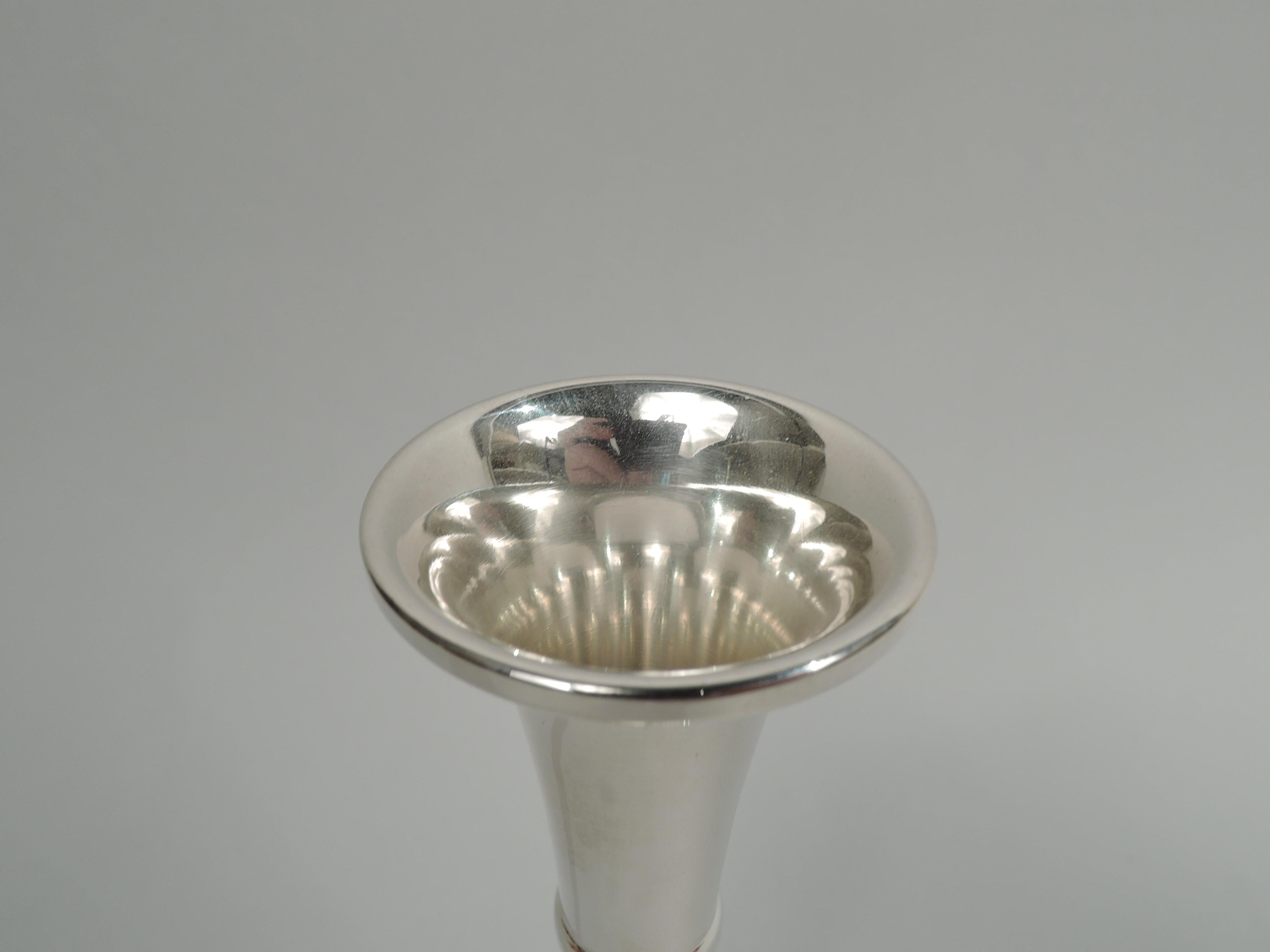 Mid-Century Modern sterling silver bud vase. Retailed by Cartier in New York. Girdled cone on raised and round foot with open and stylized leaf and flower sides. Marked “Cartier Sterling 390”. Weight: 2.8 troy ounces.