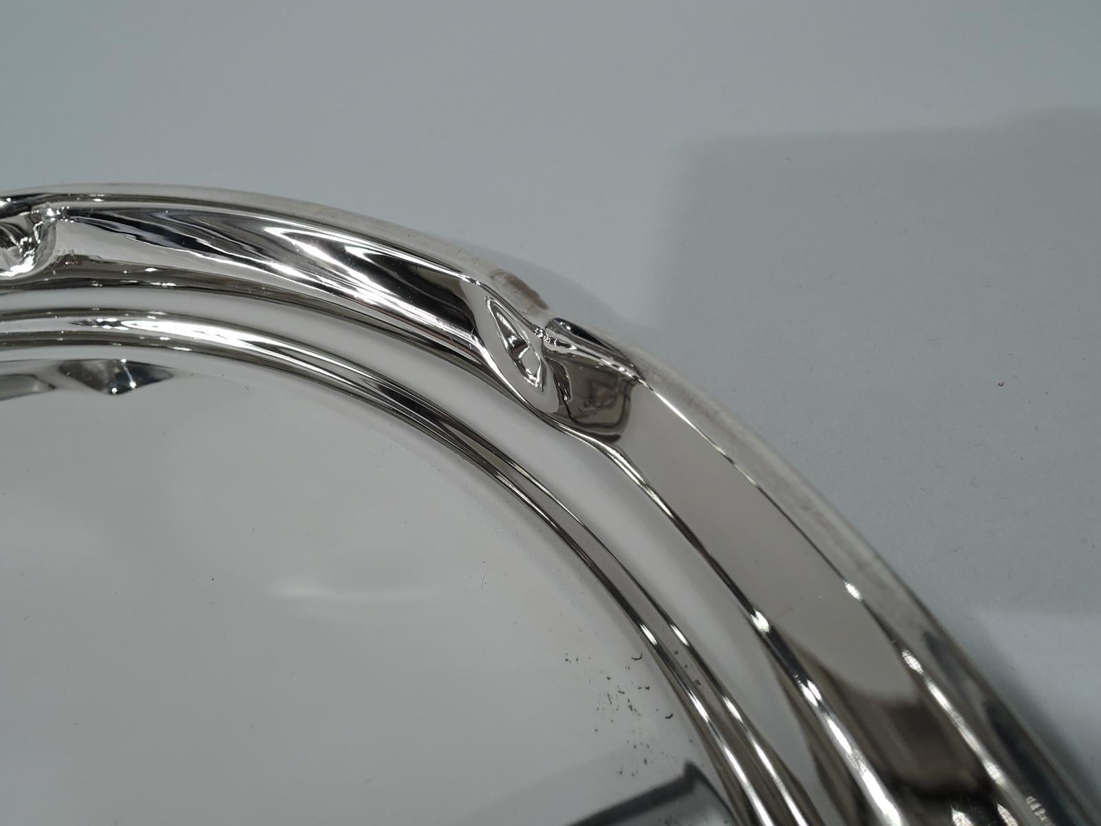 Modern sterling silver serving tray. Retailed by Cartier in New York. Round with curved sides and crimped lobed rim. Hallmark includes retailer’s stamp and no. 245/11. Weight 17.5 troy ounces.