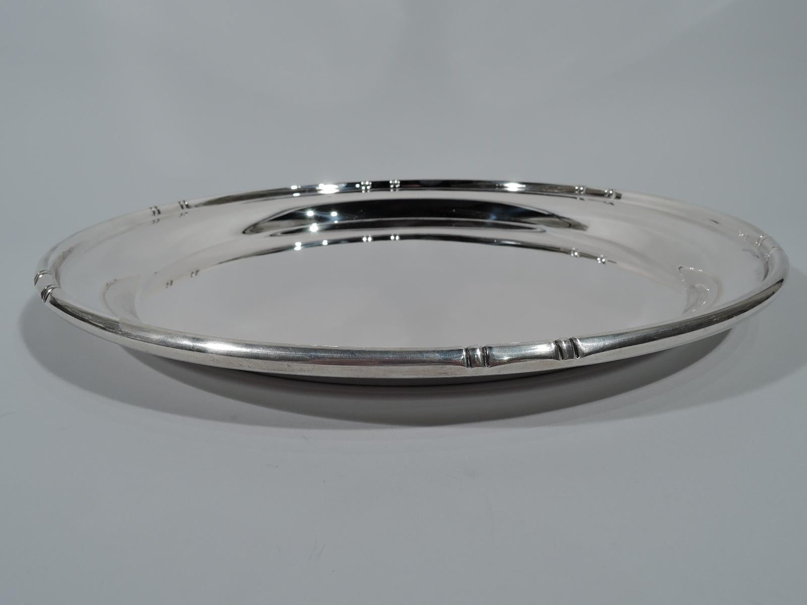 Modern sterling silver tray in Bamboo pattern. Retailed by Cartier in New York. Circular with notched bamboo-style rim. This pattern made by Baldwin & Miller in Newark. Fully marked including retailer’s stamp, pattern name, and no. 975. Weight: 31