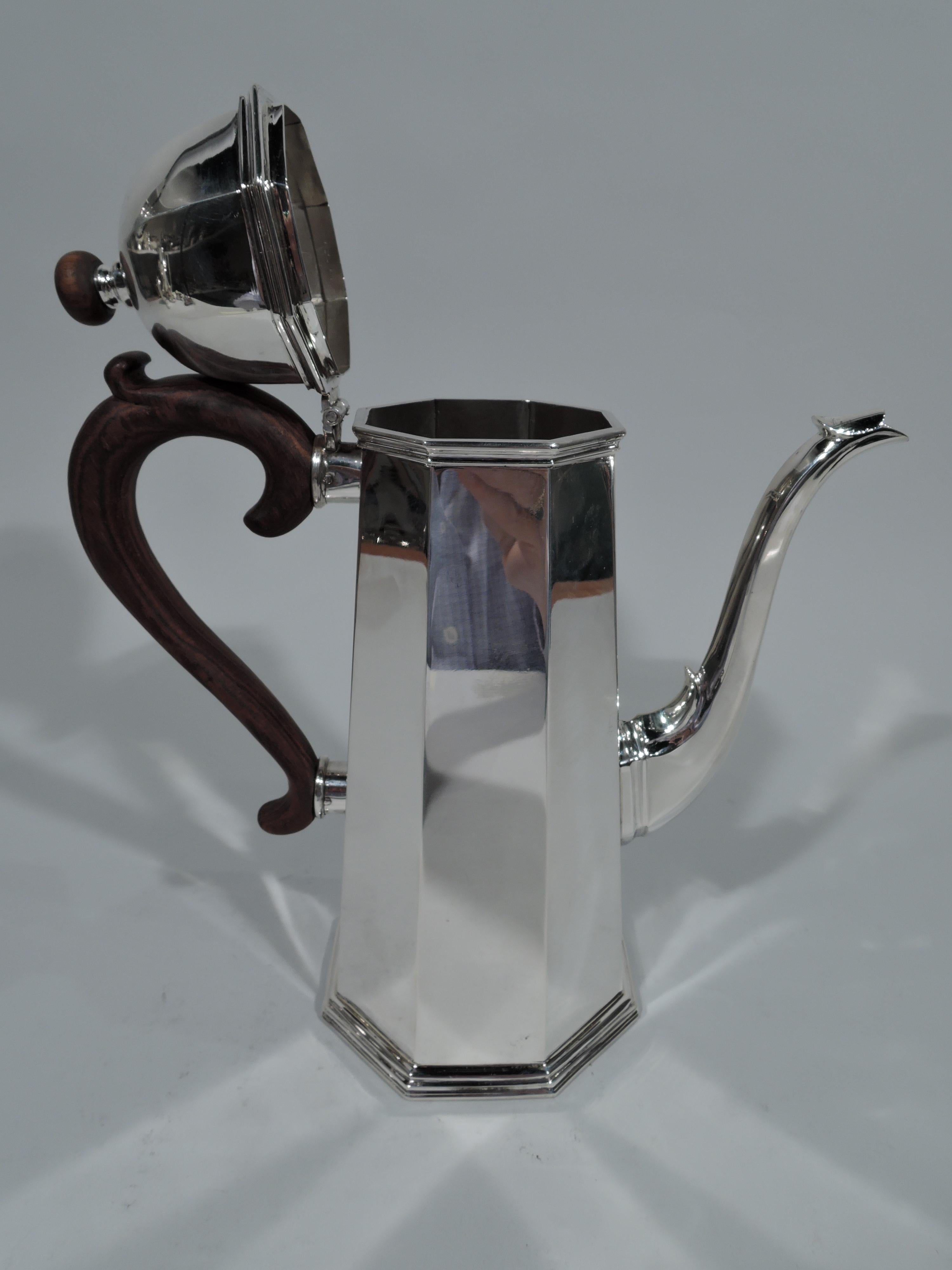 Modern Georgian sterling silver coffeepot. Retailed by Cartier in New York. Faceted and upward tapering sides. S-scroll spout same as is domed and hinged cover same with stained-wood ball finial. Capped s-scroll handle in stained wood. Molded base