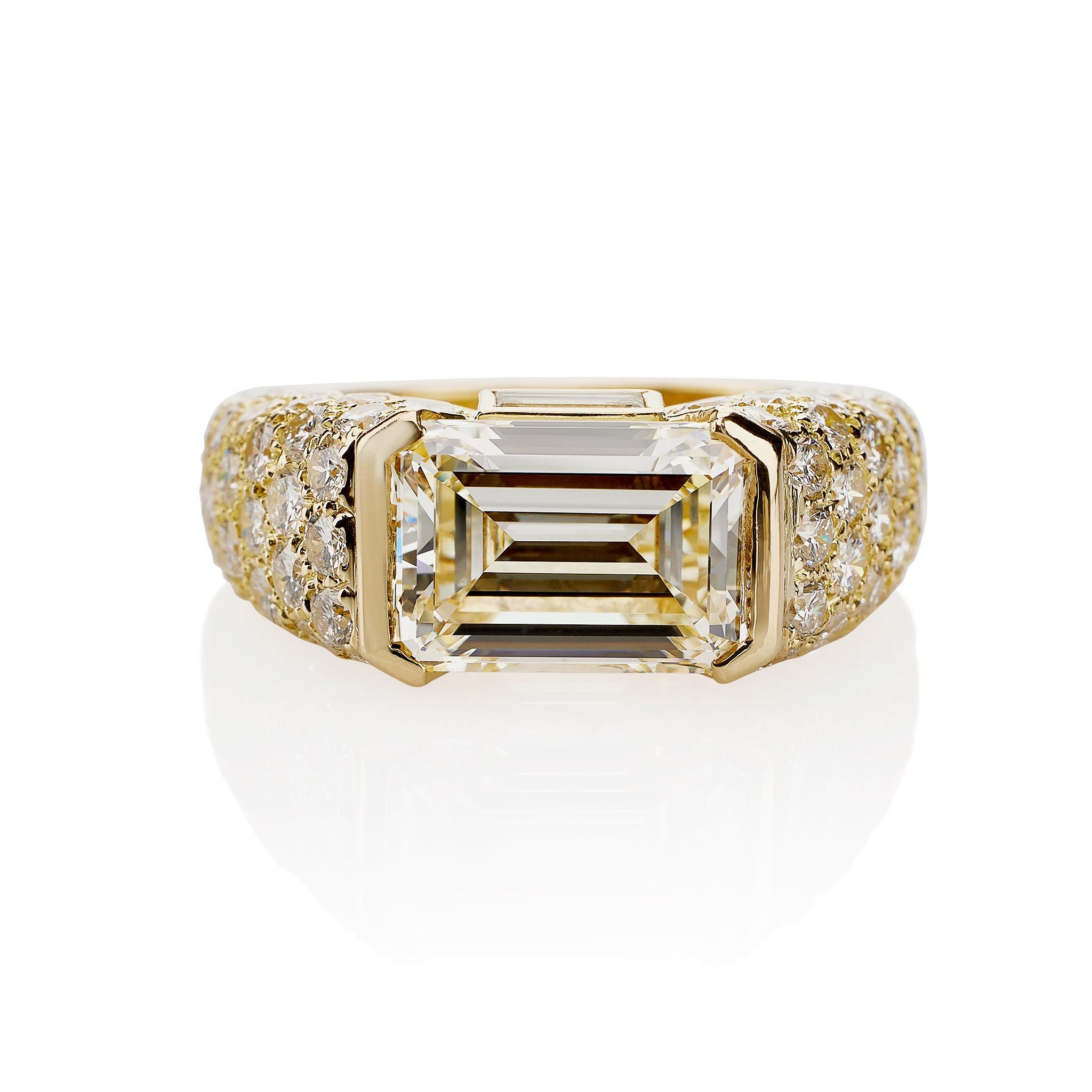 This Cartier Monture Paris ring set with an emerald-cut diamond with GIA report L color, VVS2 clarity, is mounted in 18K gold. The 4.93 carat diamond is mounted horizontally, its shoulders pavé-set with diamond melêe, and vertically flanked by