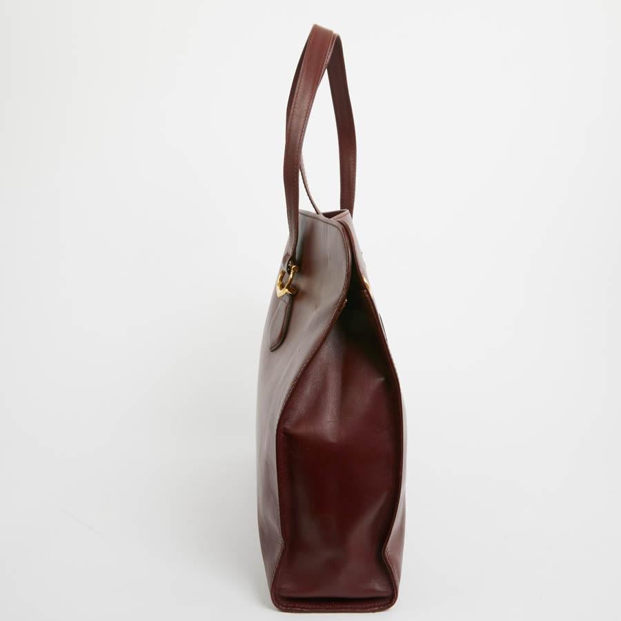 Timeless CARTIER tote in burgundy Box leather. The jewelry is golden. It is worn on the shoulder. Closing with two snaps. the interior is in leather, a large zipped pocket. Unisex.
Classic model that has survived the years, the dimensions of this