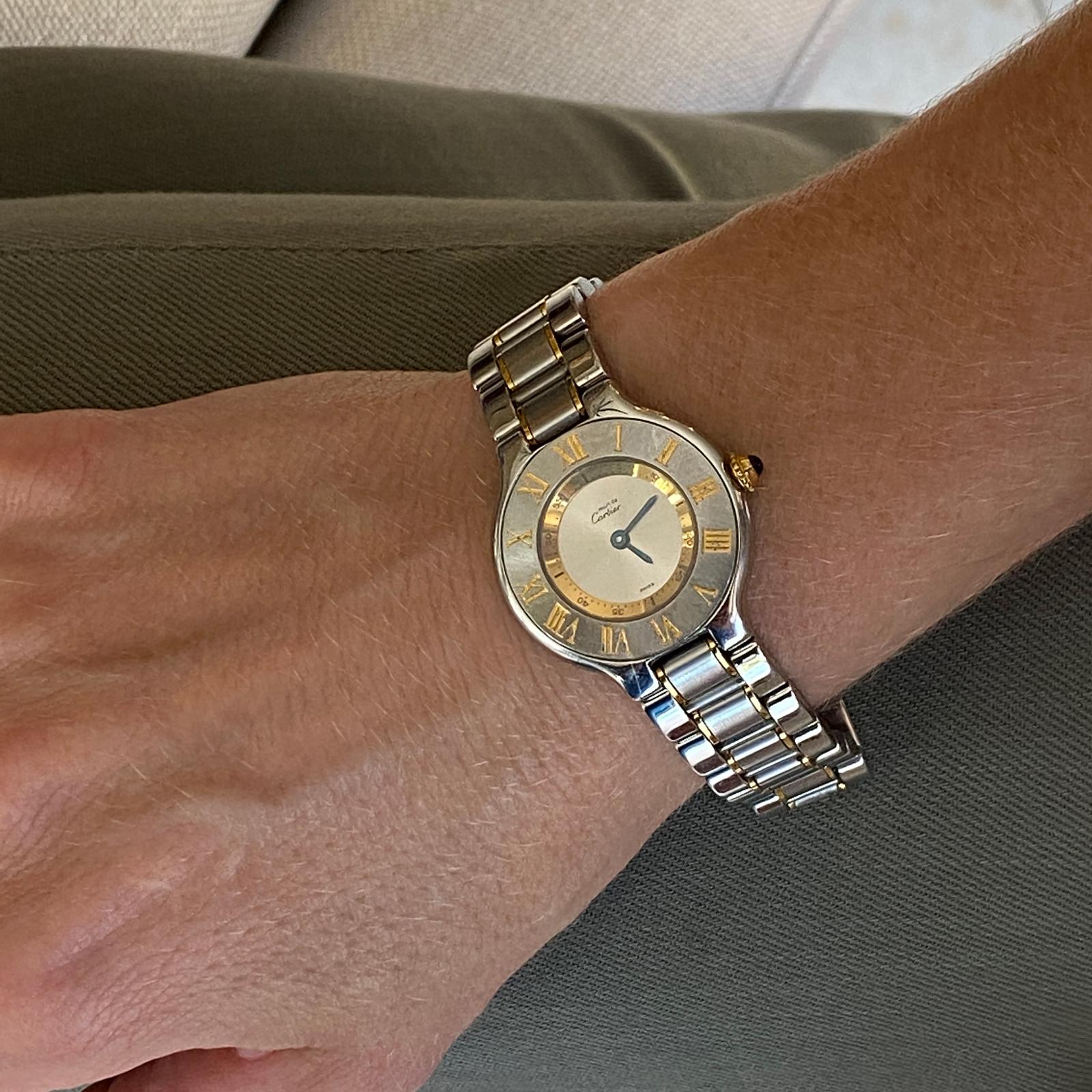 Cartier Must De 21 stainless steel and 18 karat yellow gold two tone watch. The watch measures 30mm from case to crown, is water resistant, and features a deployment buckle. Perfect working condition-new battery. 