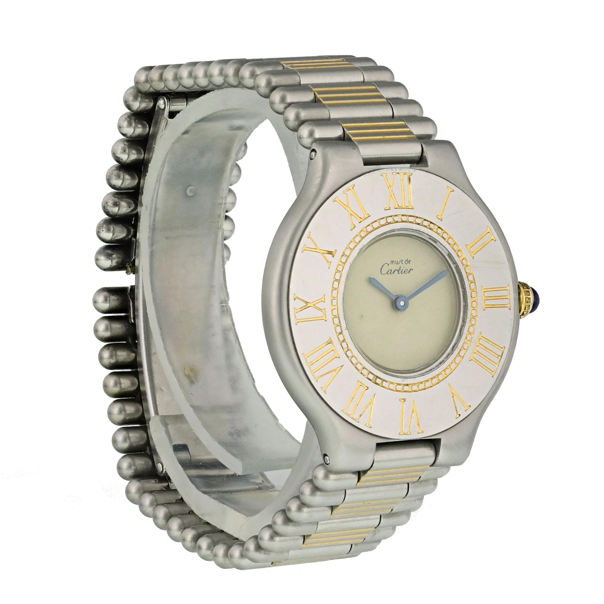 Cartier Must de Cartier Ladies Watch.
28mm Stainless Steel case. 
Stainless Steel bezel with Roman numeral hour markers. 
Minute markers on the inner bezel.
Off-White dial with Blue steel hands. 
Stainless Steel Bracelet with Butterfly Clasp. 
Will