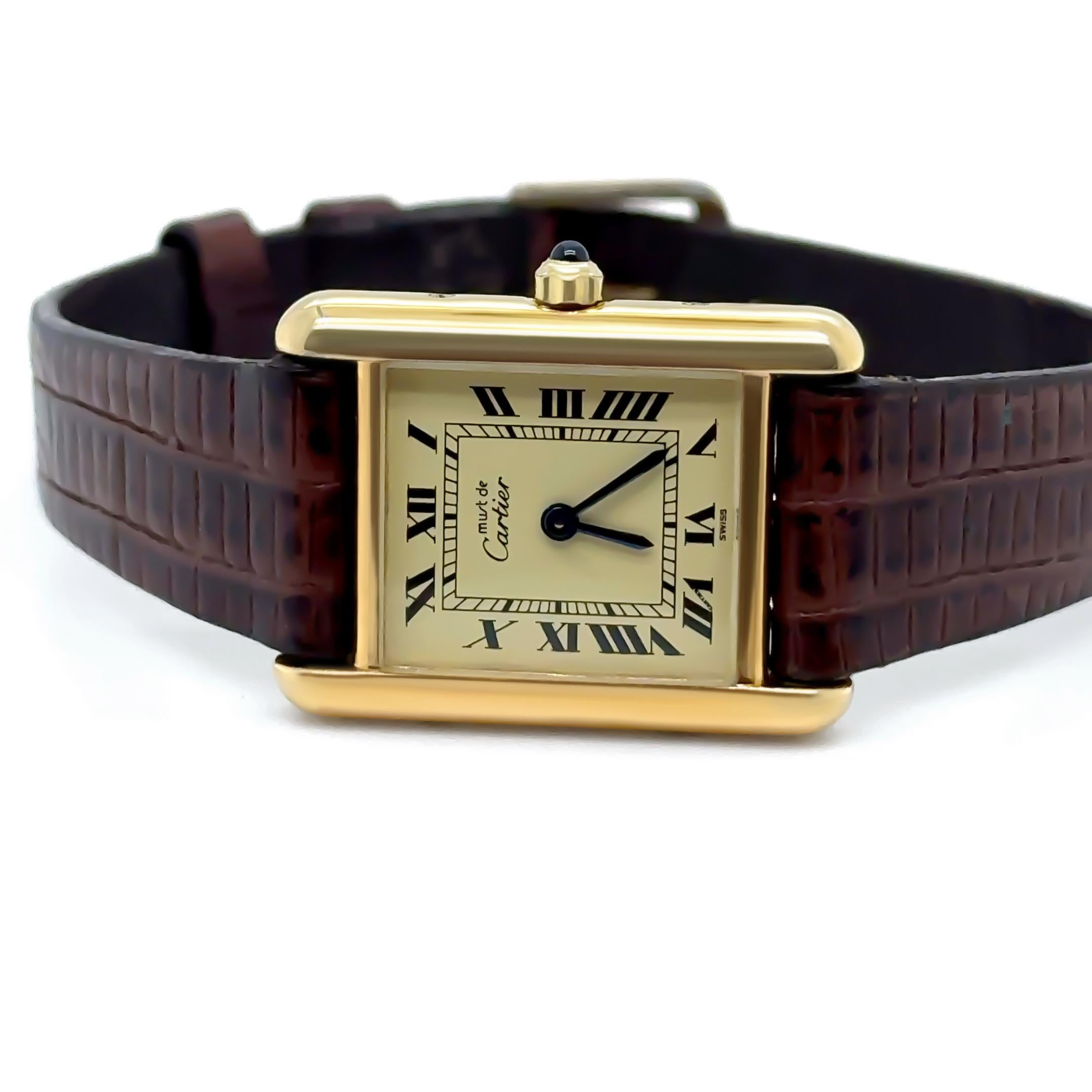 Diese elegante Damenarmbanduhr Must de Cartier Tank Vermeil strahlt zeitlose Raffinesse aus. Sie verfügt über ein vergoldetes Sterlingsilbergehäuse mit den klassischen Tank-Proportionen von 20 x 28 mm. Die Uhr läuft mit einem zuverlässigen Quarzwerk