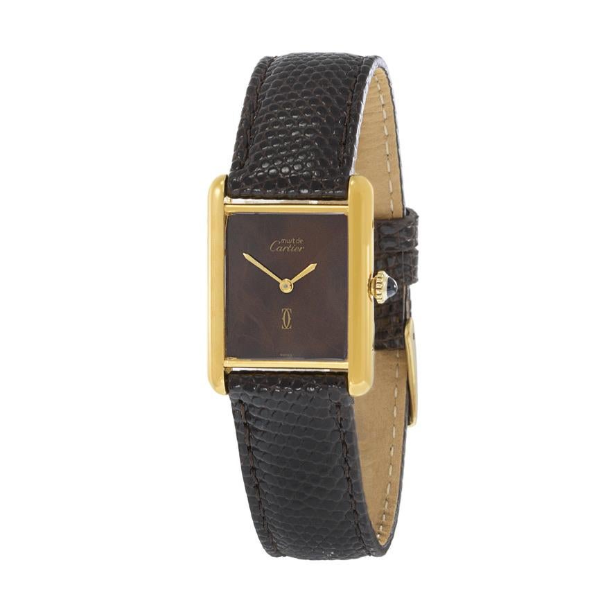 Dies ist ein Vintage 1980's Vermeil manuelle Wind Cartier Must de Cartier Tank. Das Gehäuse besteht aus Sterlingsilber, das mit 18 Karat Gelbgold überzogen ist. Das Gehäuse misst 23,5 mm x 30,5 mm. Diese Uhr hat ein seltenes braunes Zifferblatt mit
