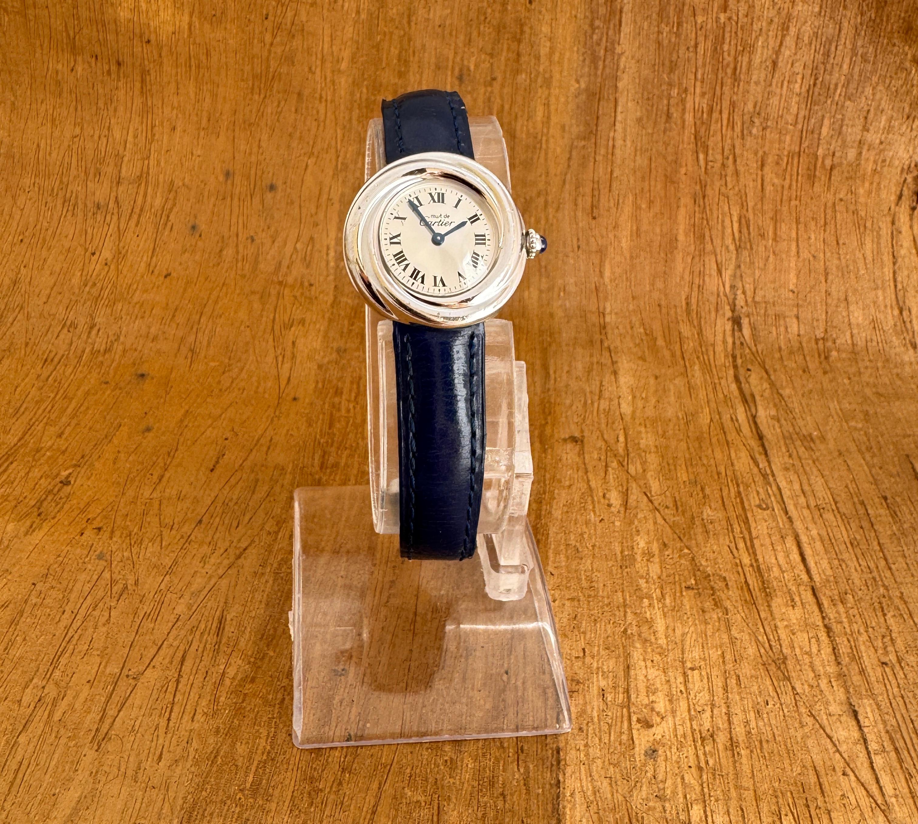 Marca: Cartier

Model No: Trinidad

Número de referencia: 2439

País de fabricación: Suiza

Movimiento: Cuarzo

Material de la caja: Plata

Medidas : Ancho de la caja: 27 mm. (sin corona)

Tipo de correa :Piel azul Cartier original con cierre de