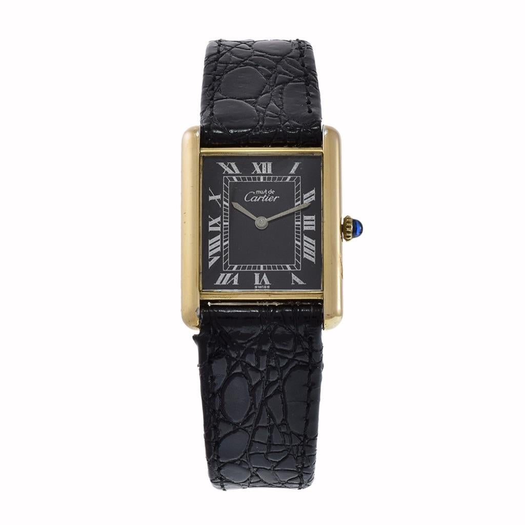 Introducing the Cartier Tank Vermeil Watch: Timeless Elegance.

Embrace refined luxury with the Cartier Tank Vermeil Watch. This iconic timepiece from the 1970s boasts a black dial, radiating timeless sophistication. The 23.5mm x 30.5mm dimensions