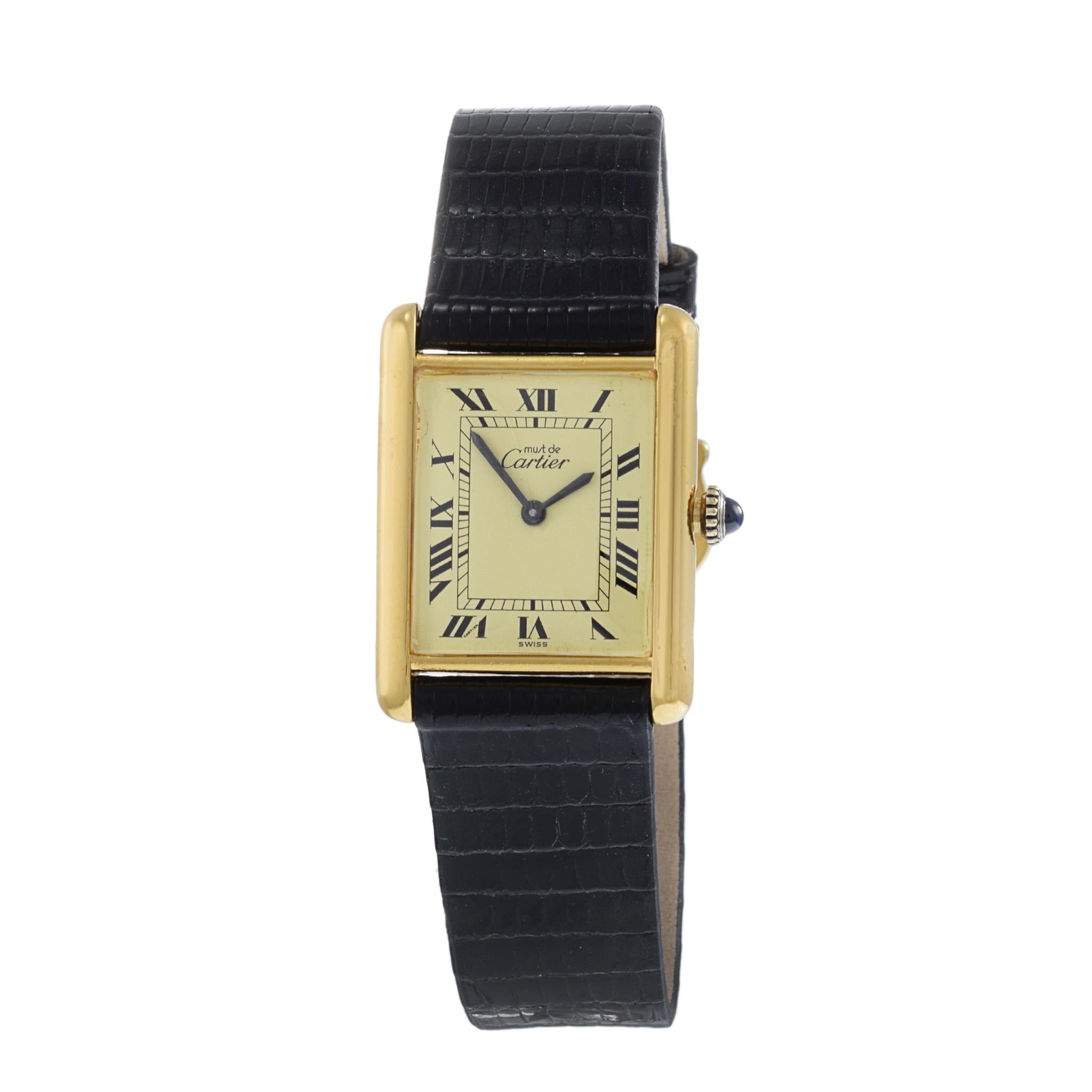 Vintage 1980's Mechanical Must de Cartier Paris, 23,5 mm x 30,5mm .925 Vermeil 18KT vergoldetes Gehäuse mit einem Beige Zifferblatt mit schwarzen römischen Ziffern und blauen schwertförmigen Händen, Must De Cartier.

Diese Uhr wurde getestet und
