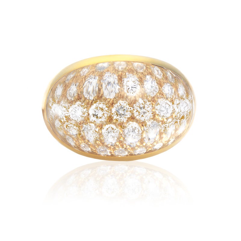 With a majestic combination of glittering diamonds and crystal this Cartier ring represents one of the best examples of high-end jewelry. Its creatively designed 18K yellow gold body is embellished on top with diamonds and crystals entwined,