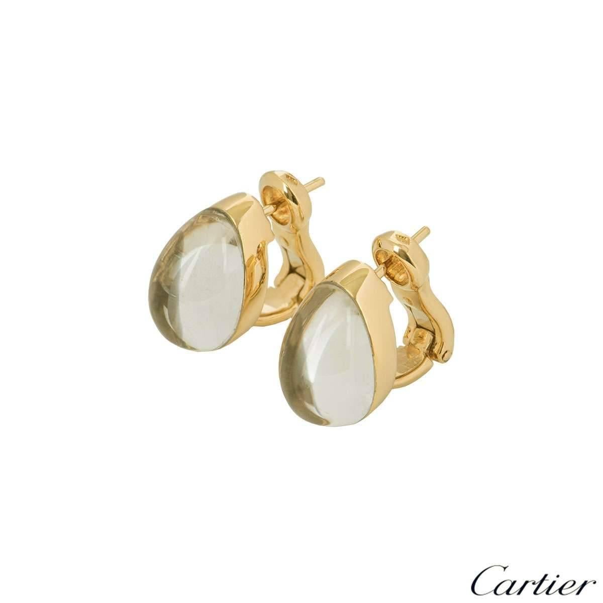 A pair of exquisite 18k yellow gold crystal and diamond earrings part of the Myst collection by Cartier. The earrings feature a domed rock crystal in an oval shape with a triple row of round brilliant cut diamonds embedded behind the layer of