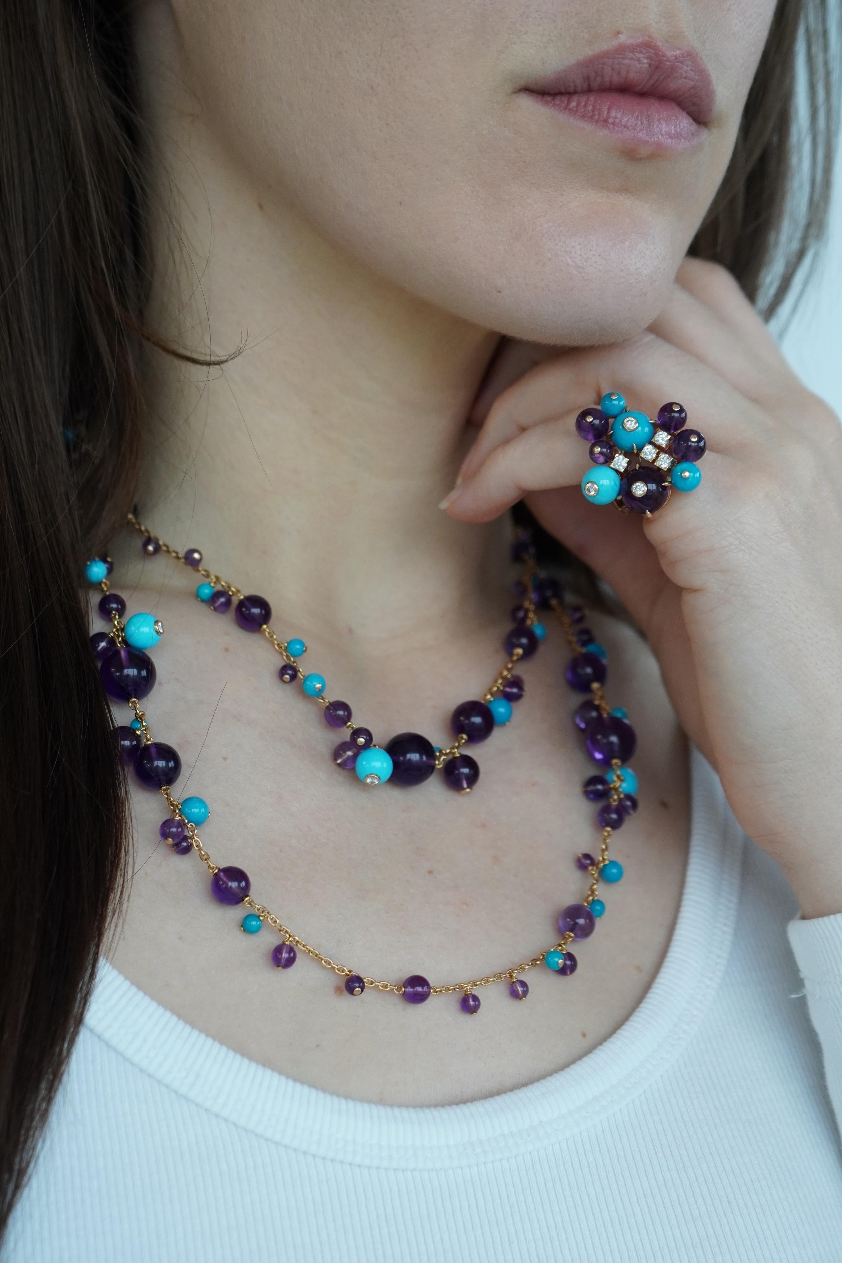 This Cartier jewelry set, circa in 2007, features a vibrant combination of amethyst and turquoise beads accented with diamonds throughout. Made from 18k yellow gold, the set includes a necklace and a matching ring. The necklace measures 38 inches in