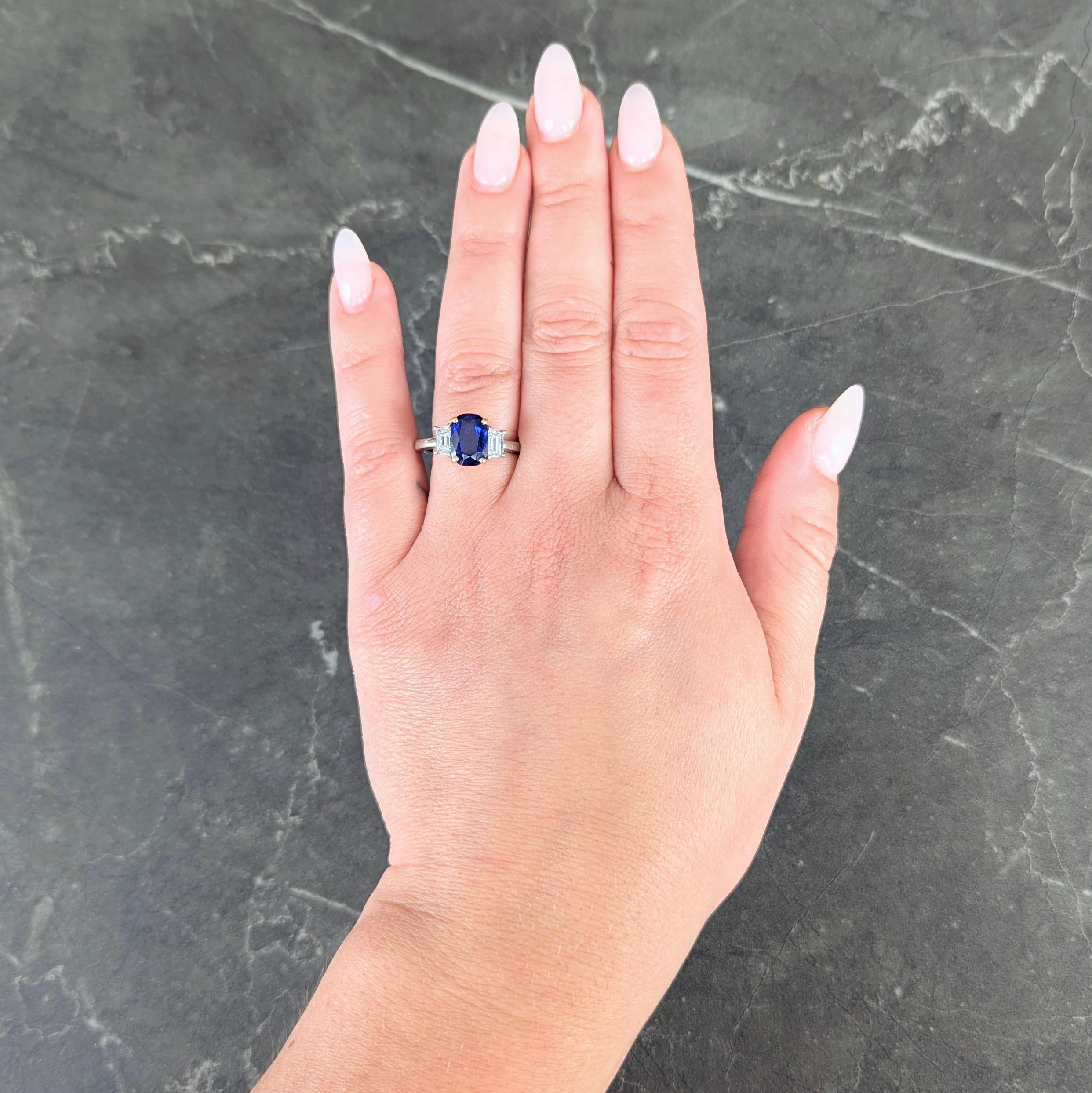 Centering a cushion cut sapphire weighing 2.80 carats - transparent medium blue
Natural Madagascar in origin and displaying no indications of heat treatment
Prong set in yellow gold and flanked by tapered baguette cut diamonds
Weighing approximately
