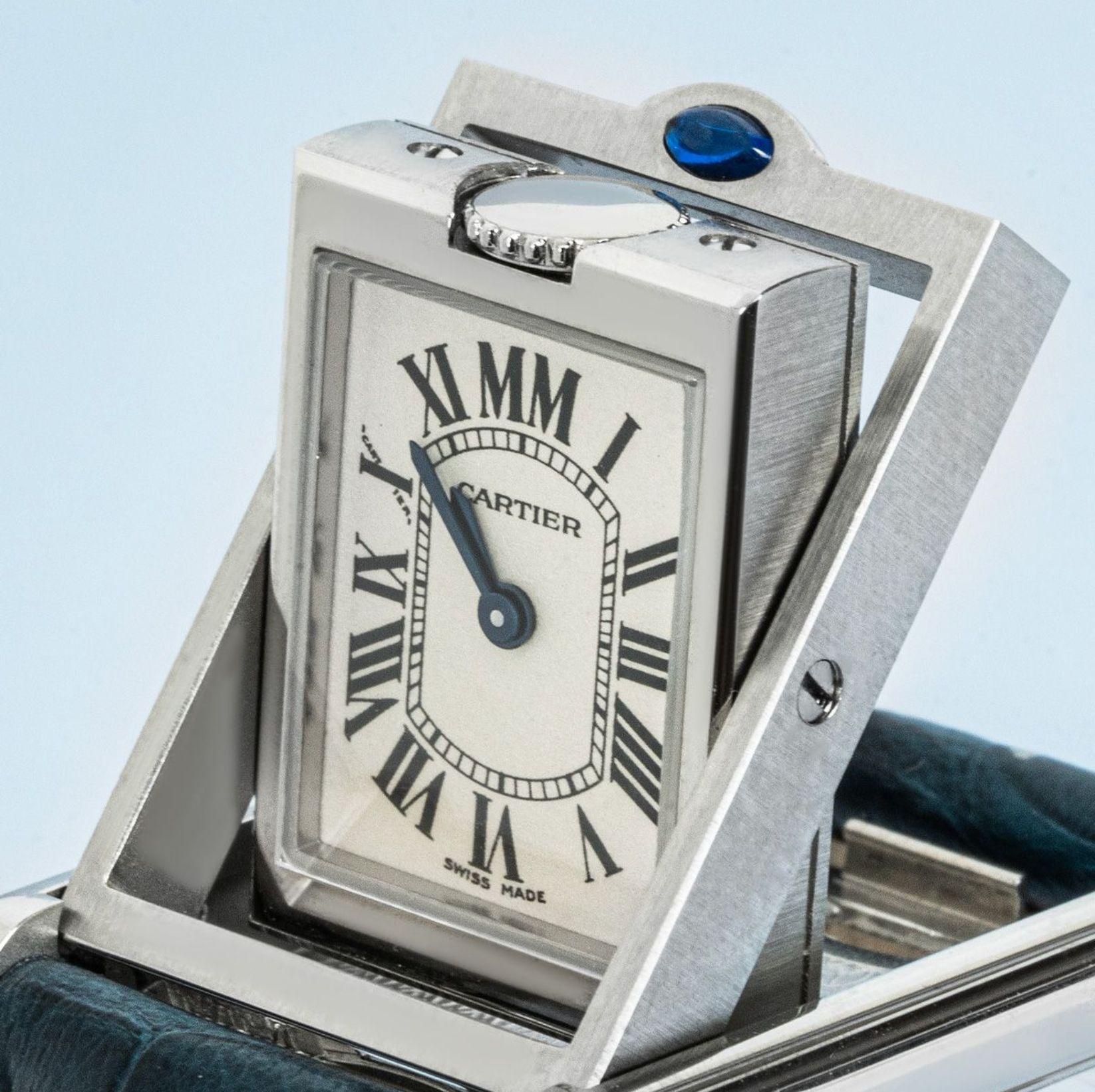 A 22mm stainless steel Tank Basculante by Cartier. Featuring a silver dial with roman numerals that features a distinctive MM at 12 o'clock, blued steeled sword-shaped hands, a secret Cartier signature at X and a stainless steel bezel. The watch