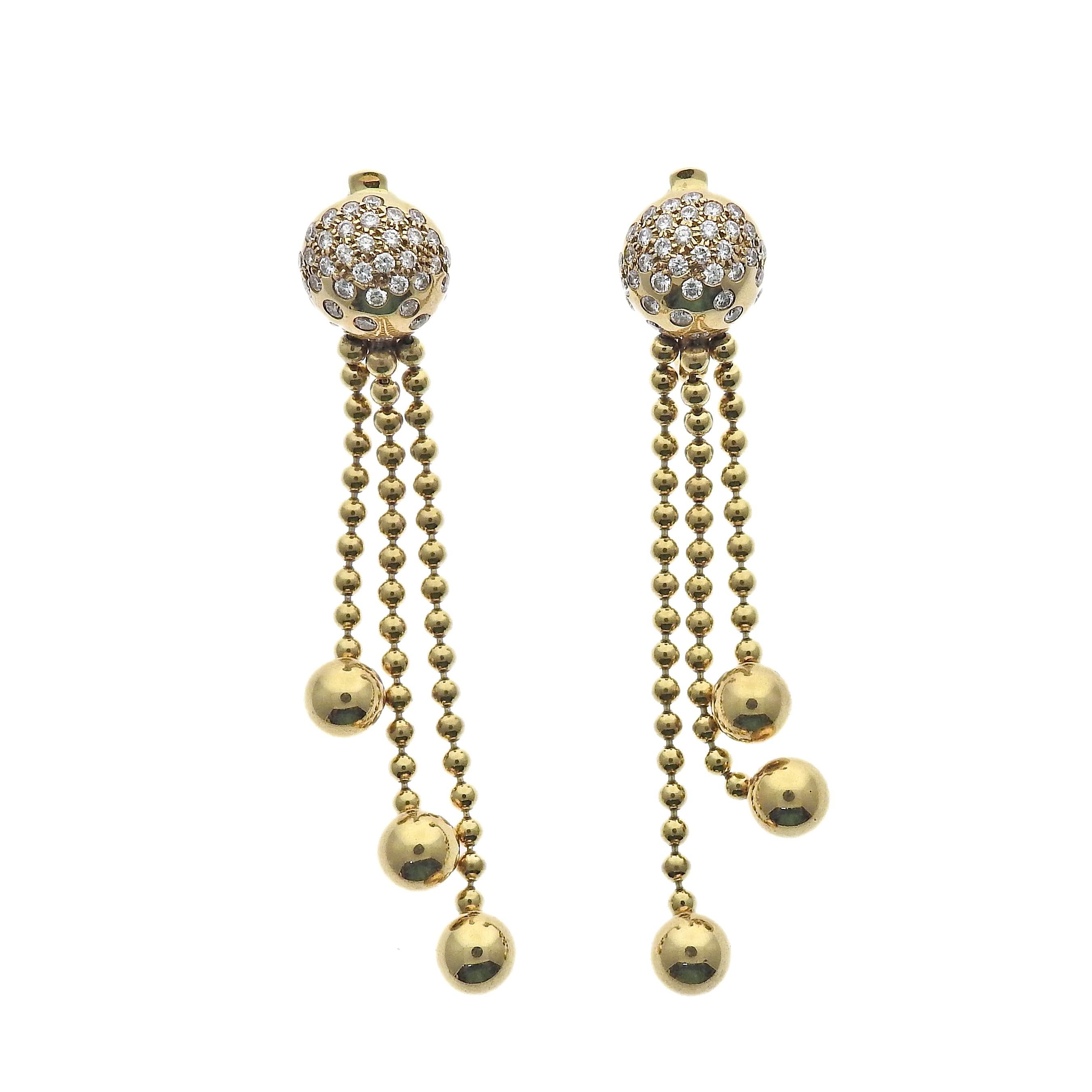 18k yellow gold drop earrings, crafted by Cartier for the Nouvelle Vague collection, set with 0.94ctw in VVS/F-G diamonds. Earrings measure 59mm long. Marked: Cartier, 750, 1999, Serial Number, French punch mark. Weight is 20.6 grams.