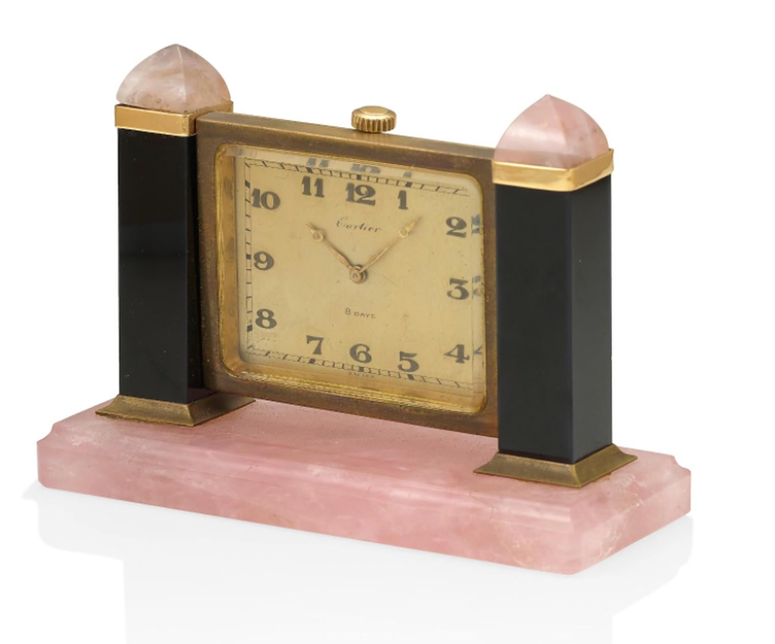 Cartier Tischuhr in einem Rahmen aus Onyx und Rosenquarz, mit einem manuellen Uhrwerk, rechteckigem Zifferblatt und arabischen Ziffern. Signiert Cartier, #6946. 
Hergestellt in Paris, um 1920.