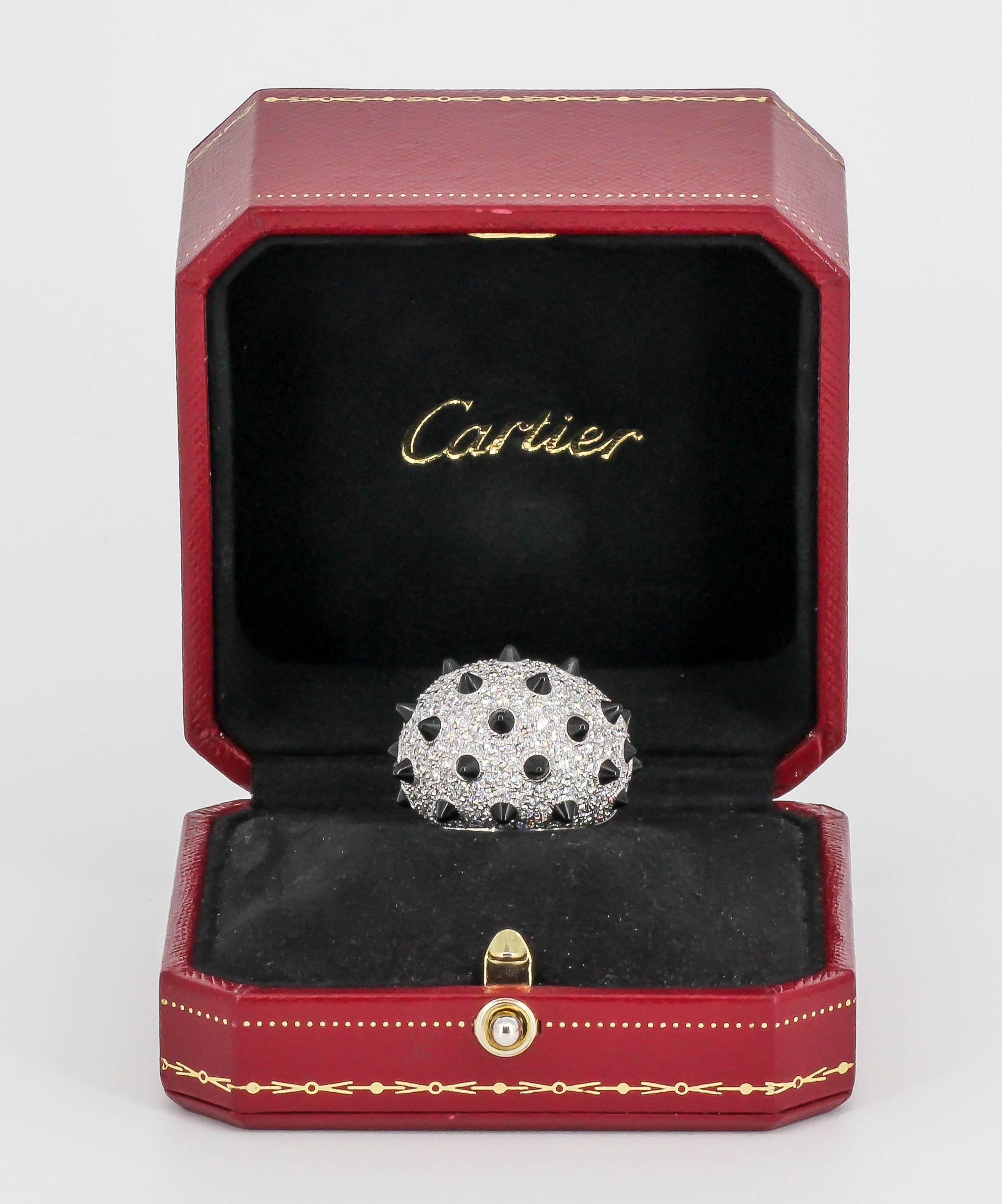 Bold and impressive onyx, diamond and 18k white gold dome ring by Cartier. It features rich black onyx stones fitted like spikes, surrounded by high grade round brilliant cut diamonds throughout, over an 18K white gold setting. Current size 54