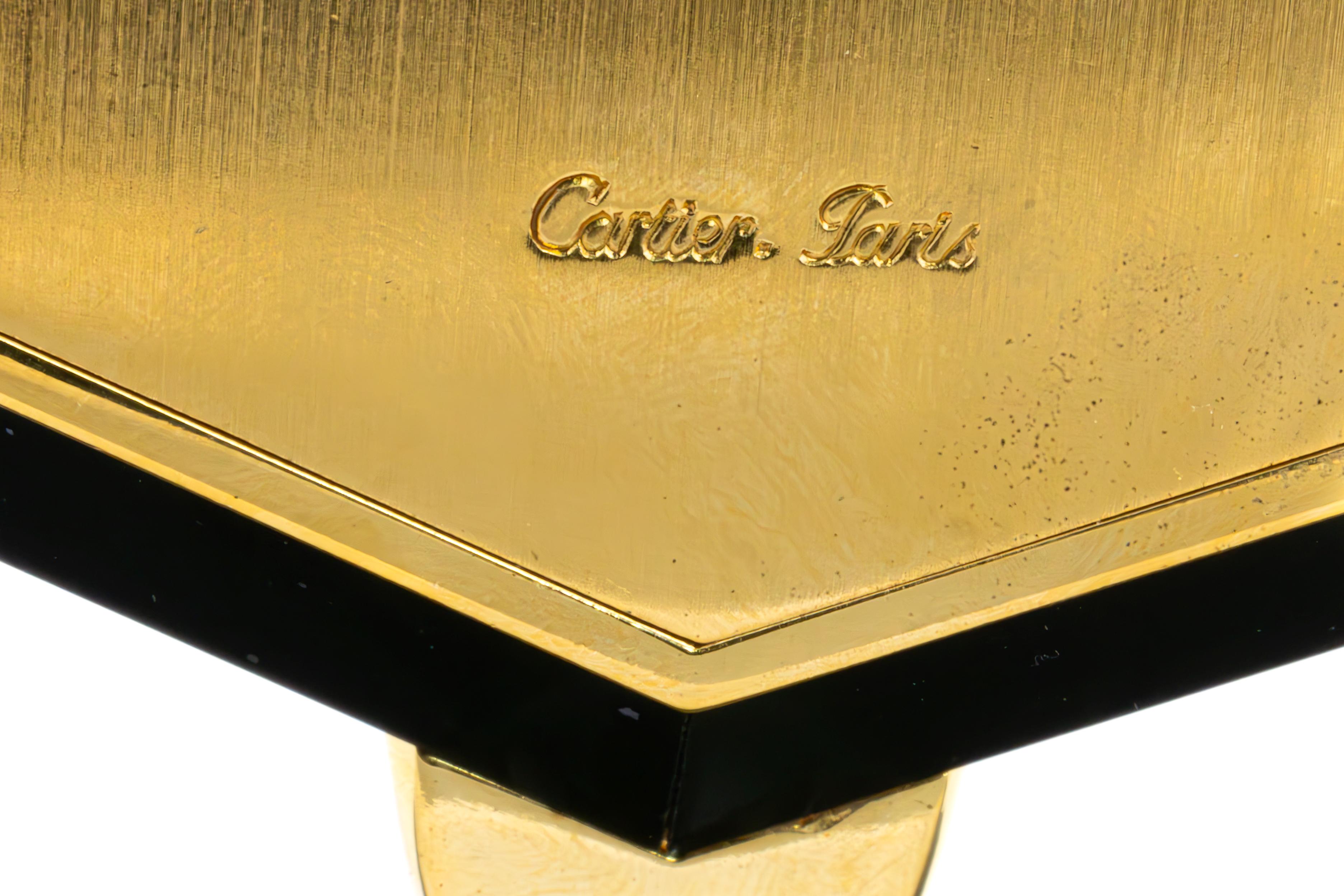 Cartier Tischuhr aus Perlmutt, Onyx und vergoldetem Messing

Beschreibung:
Diese majestätische Tischuhr von Cartier ist aus Perlmutt, Onyx und vergoldetem Messing gefertigt und verkörpert zeitlose Raffinesse. Das achteckige Ziffernblatt ist elegant