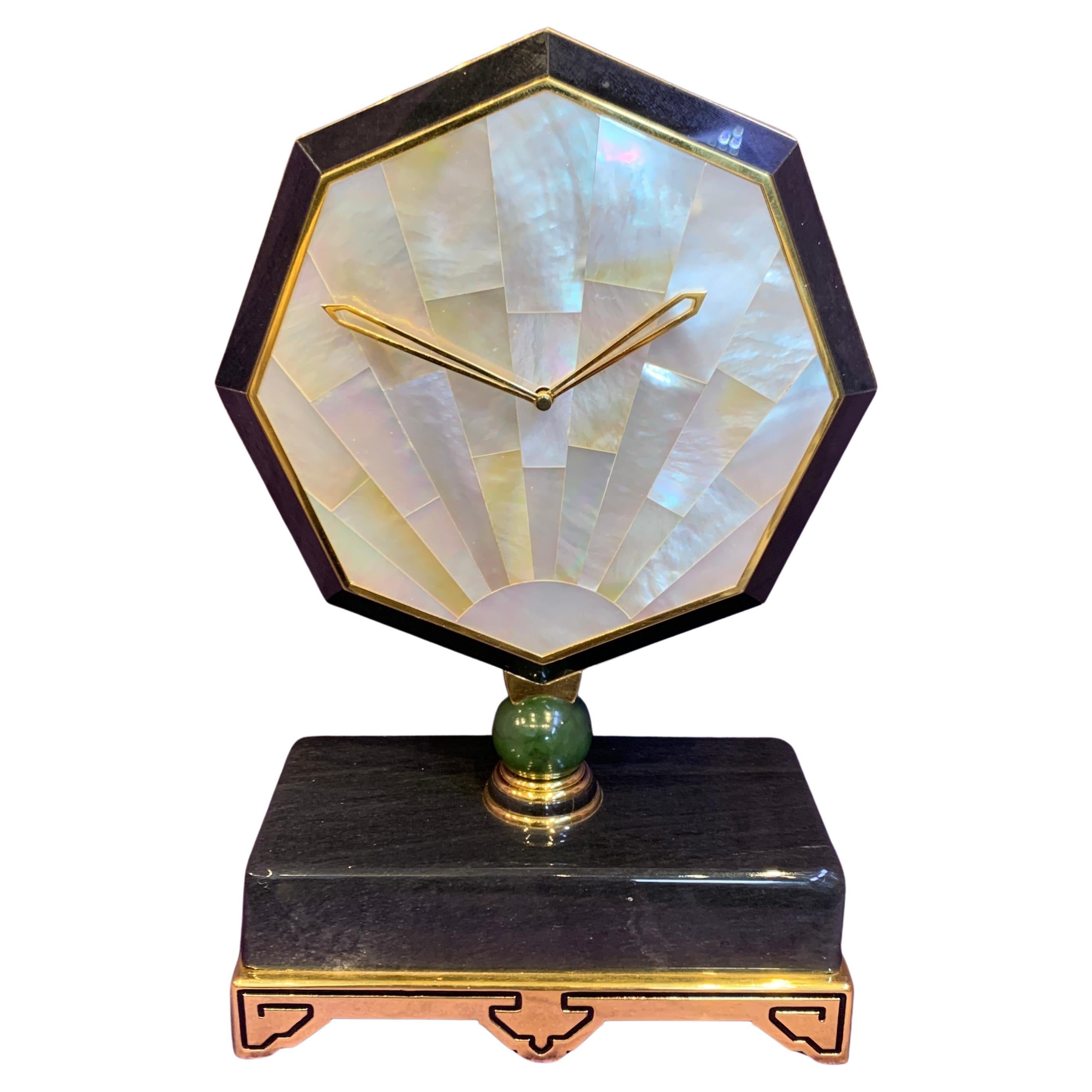 Cartier Onyx & Mother of Pearl Desk Clock

A desk clock consisting of an octagonal face made of mother of pearl, onyx, and gilt brass, with a nephrite bead connecting it to the onyx, gilt brass, and enamel base

Signed Cartier Paris and