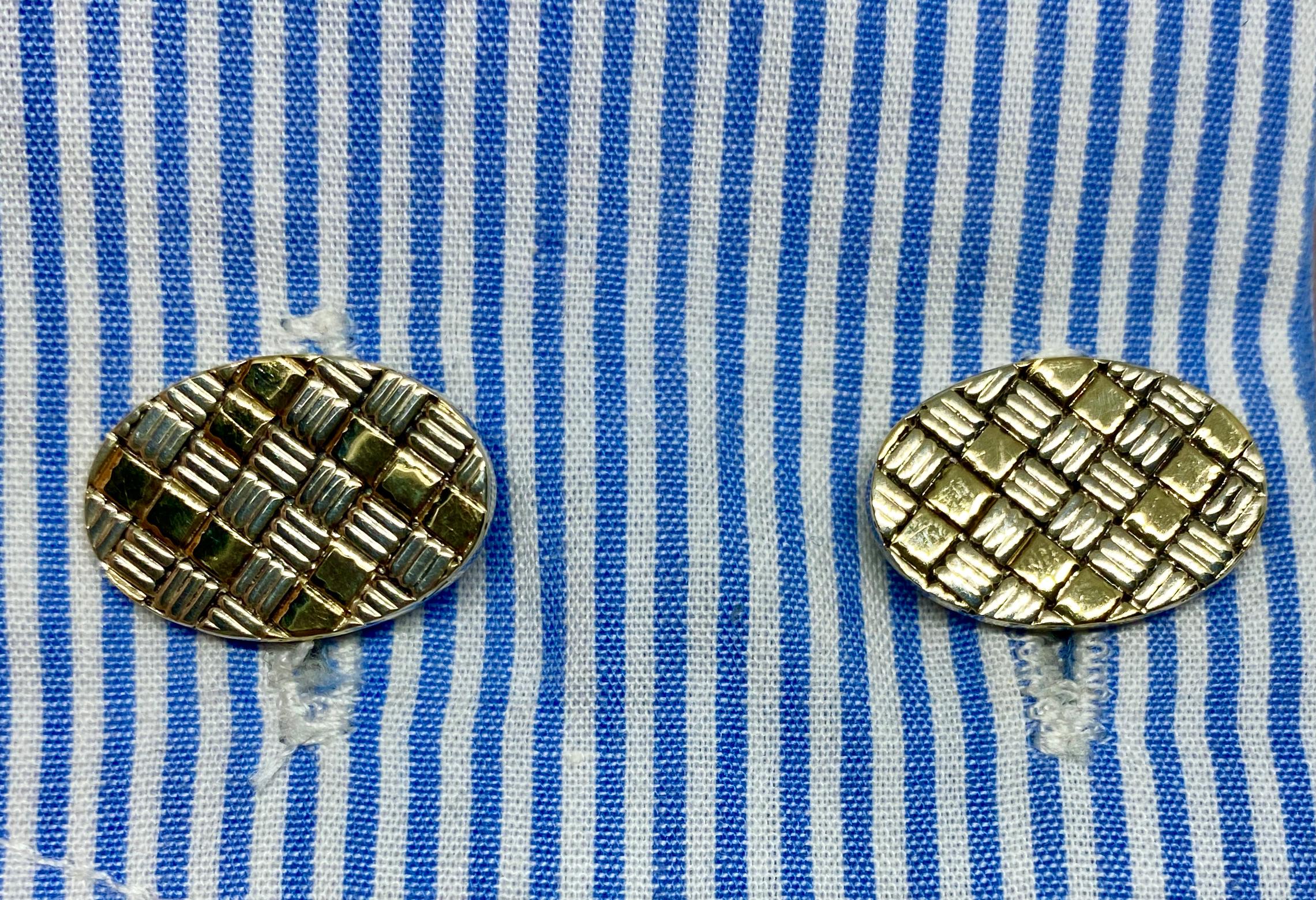 A handsome, extremely versatile pair of cufflinks in a checkerboard design rendered in 18K yellow gold and sterling silver by Cartier.

The four oval faces each measures 18.7 by 12.7mm and is joined to its mate by sterling silver connectors.  One