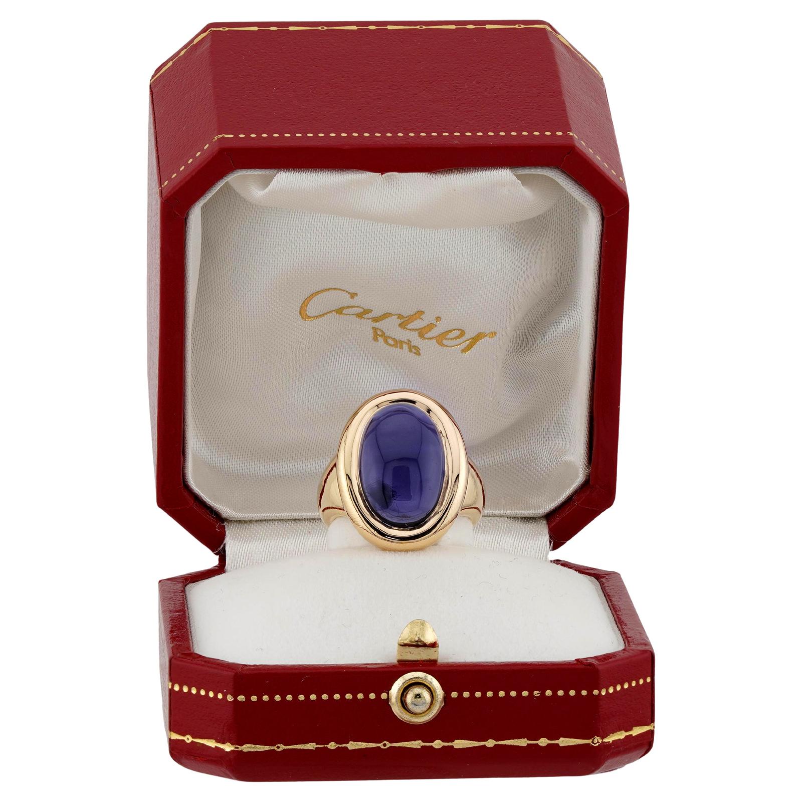 This gorgeous authentic Cartier ring is crafted in 18k yellow gold and bezel-set with an oval purple iolite. Made in France circa 1994. Measurements: 0.47