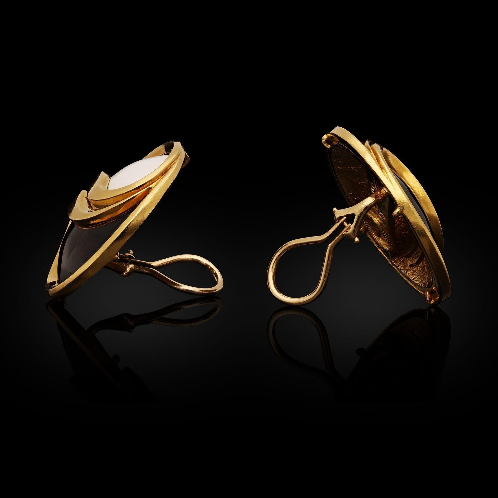 A bold pair of Yin and Yang gold and enamel earrings by Cartier c.1980s, each earring formed as a large round disc with domed profile in 18ct gold, the front bisected by a double row gold swirl, one half filled with white enamel and the other black