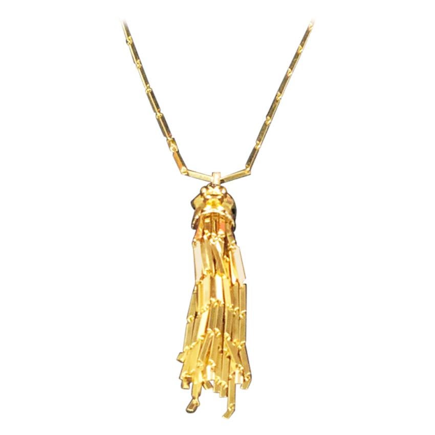 Circa 2000 Cartier, Panther de Cartier collection 18K Yellow Gold Sautoir Necklace, the Detachable Panther pendant measures 4 inches in length, has numerous fringes also having a Diamond and Onyx set collar, a Diamond set bail and Emerald set Eyes.