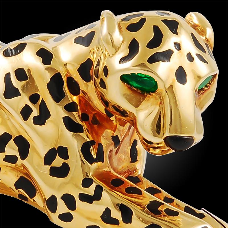 An exceptional piece portraying Cartier’s most iconic creature, the great Panther set in an 18k gold brooch, accentuated with piercing emerald eyes and onyx rosettes. A bold and enhancing statement piece. 
Signed Cartier France.