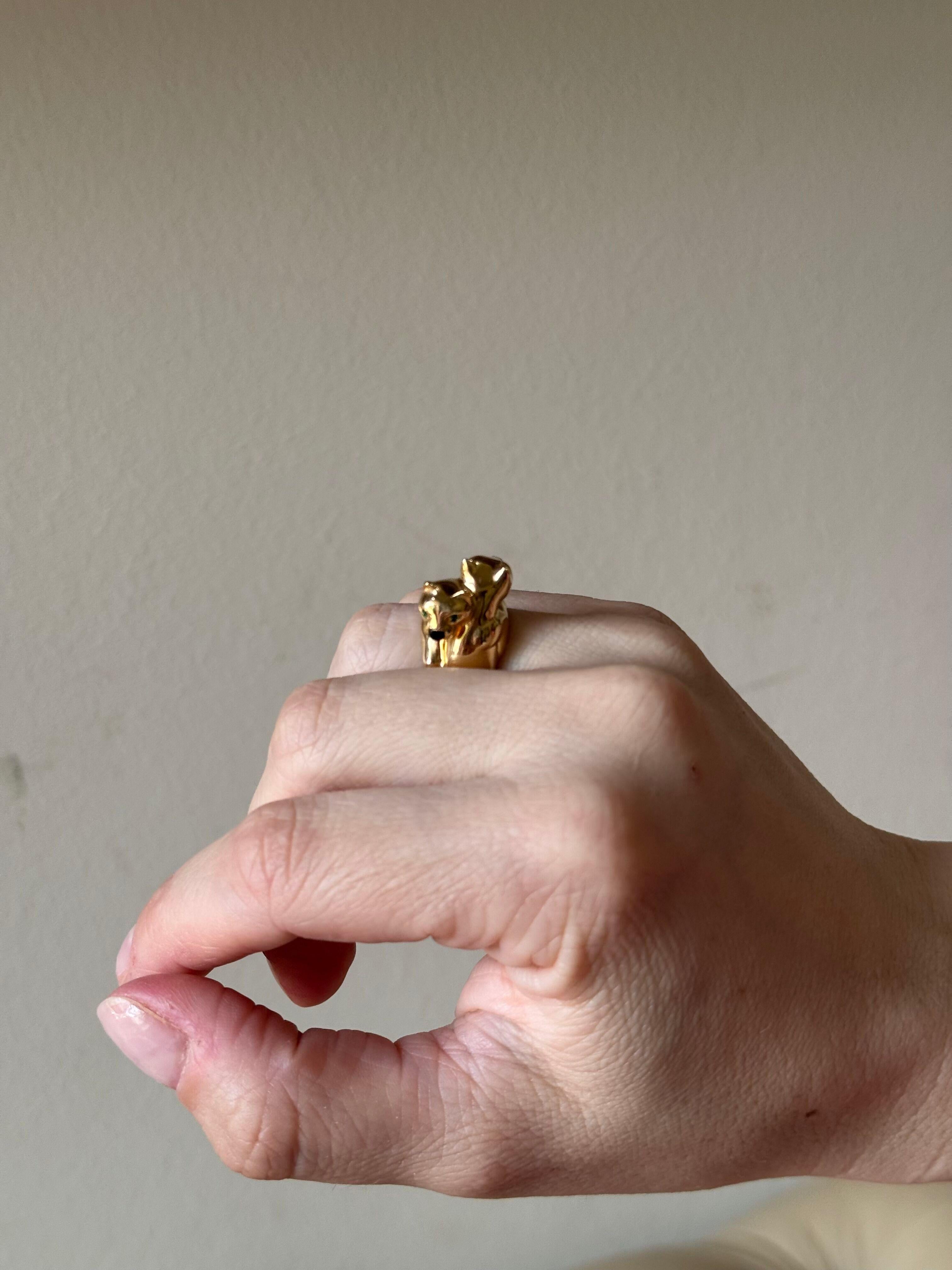 18k yellow gold bypass ring by Cartier, from Panthere collection. Panther heads decorated with onyx noses and emerald eyes.
Ring is a size 6.5 (Eu 54) , width of the top 14mm. 
Marked: 750, Cartier, 54, 989 449. 
Weight - 15.1 grams.