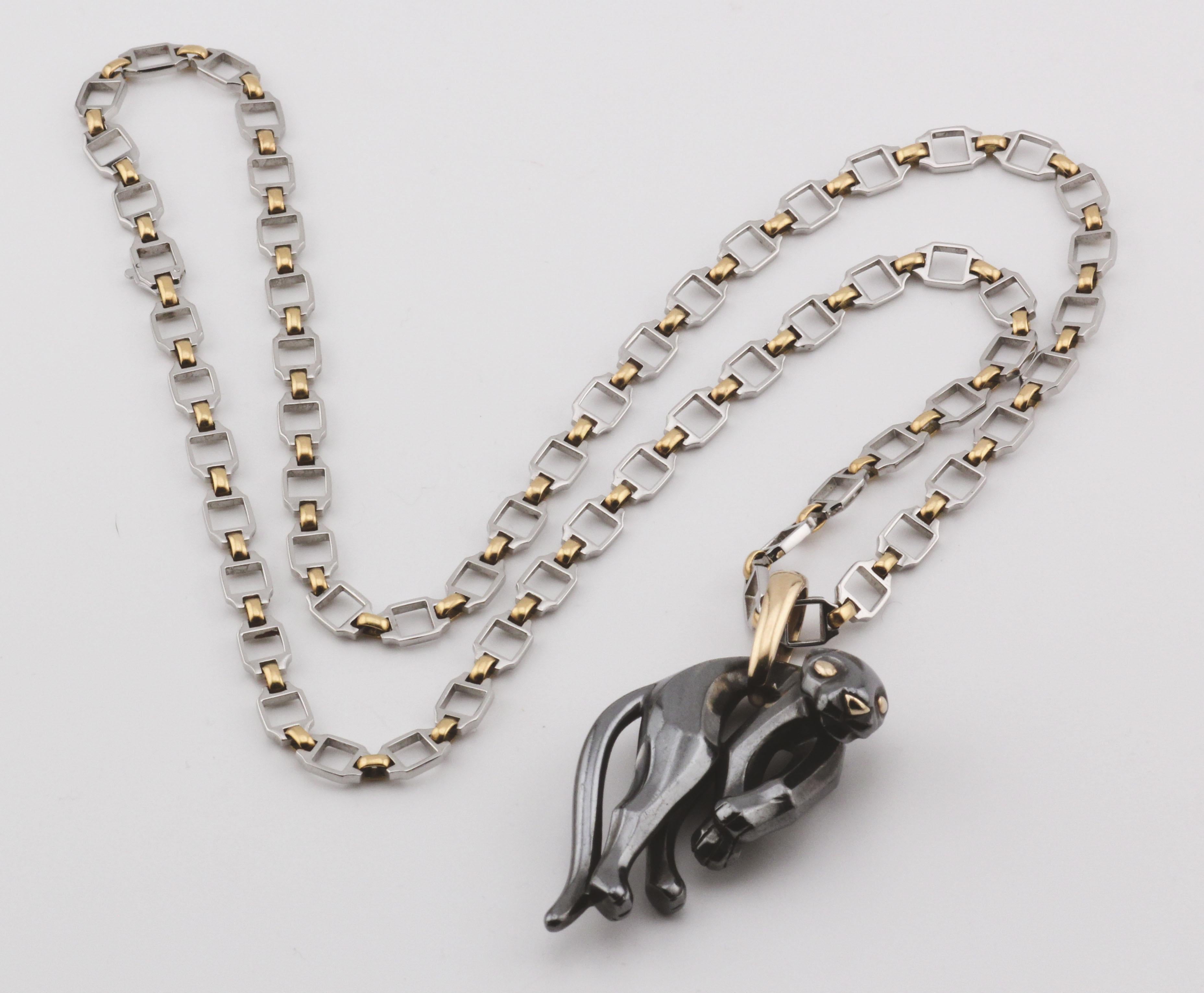 Die Cartier Panthère 18K Gold Silverium Anhänger mit Santos Steel Gold Long Necklace ist ein markantes und luxuriöses Stück, das den ikonischen Stil und die Handwerkskunst von Cartier widerspiegelt. 

Der Anhänger aus 18-karätigem Gold und Silverium