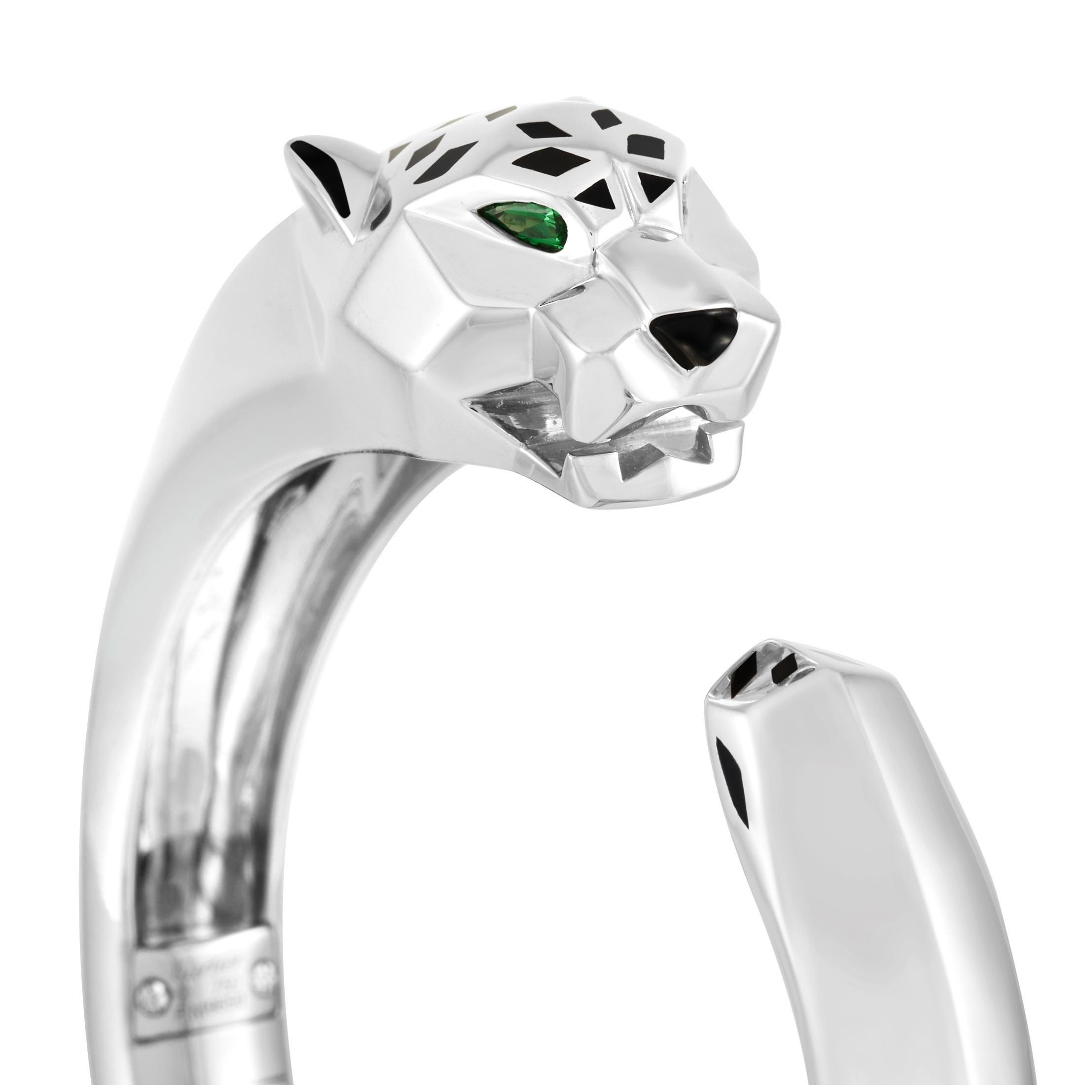 From Cartier's iconic Panthère collection, this open bangle is crafted from 18K white gold and weighs 93 grams. The mythical animal accent features emerald eyes and an onyx nose. This stunning bracelet will look perfect on the wrist of someone who